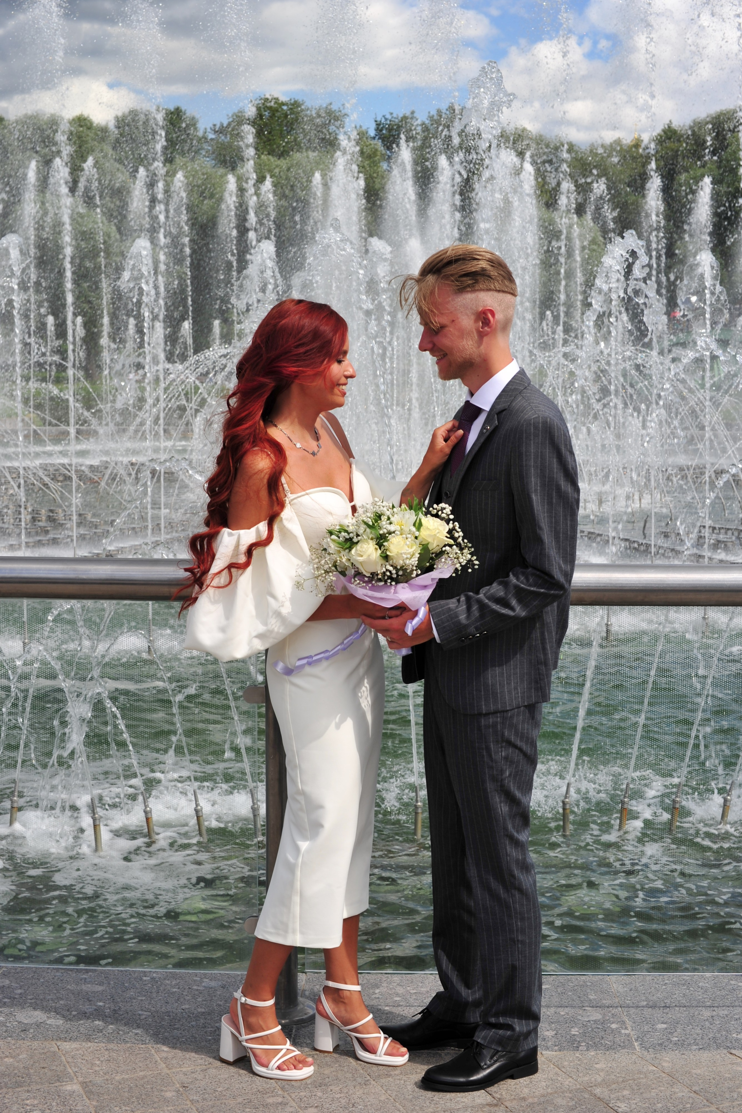 Свадьба в Царицыно летом, молодожены смотрят друг на друга на фоне фонтанов