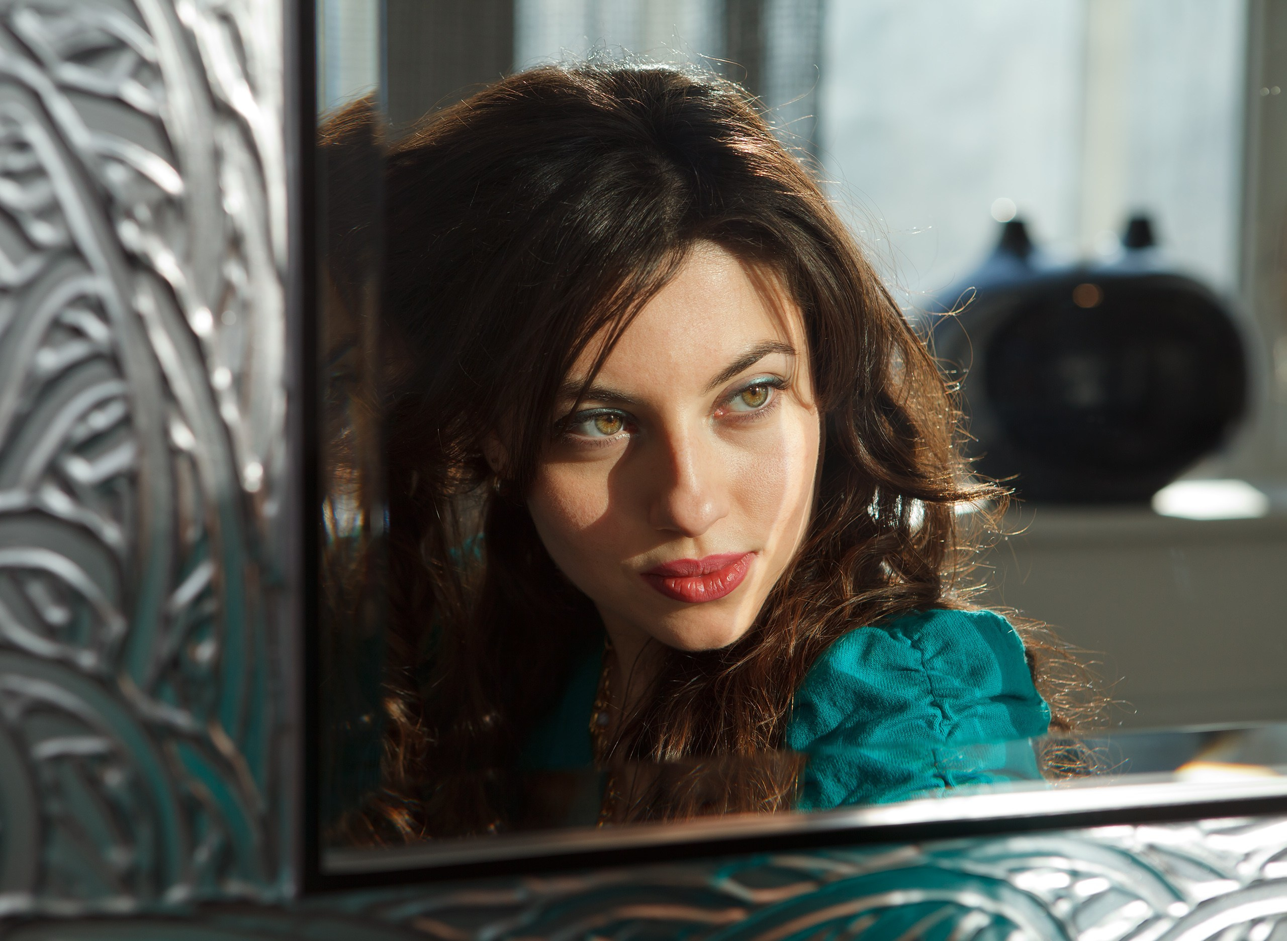 Отражение женского лица в зеркале с серебрянной рамой. Портрет девушки в зеркале.