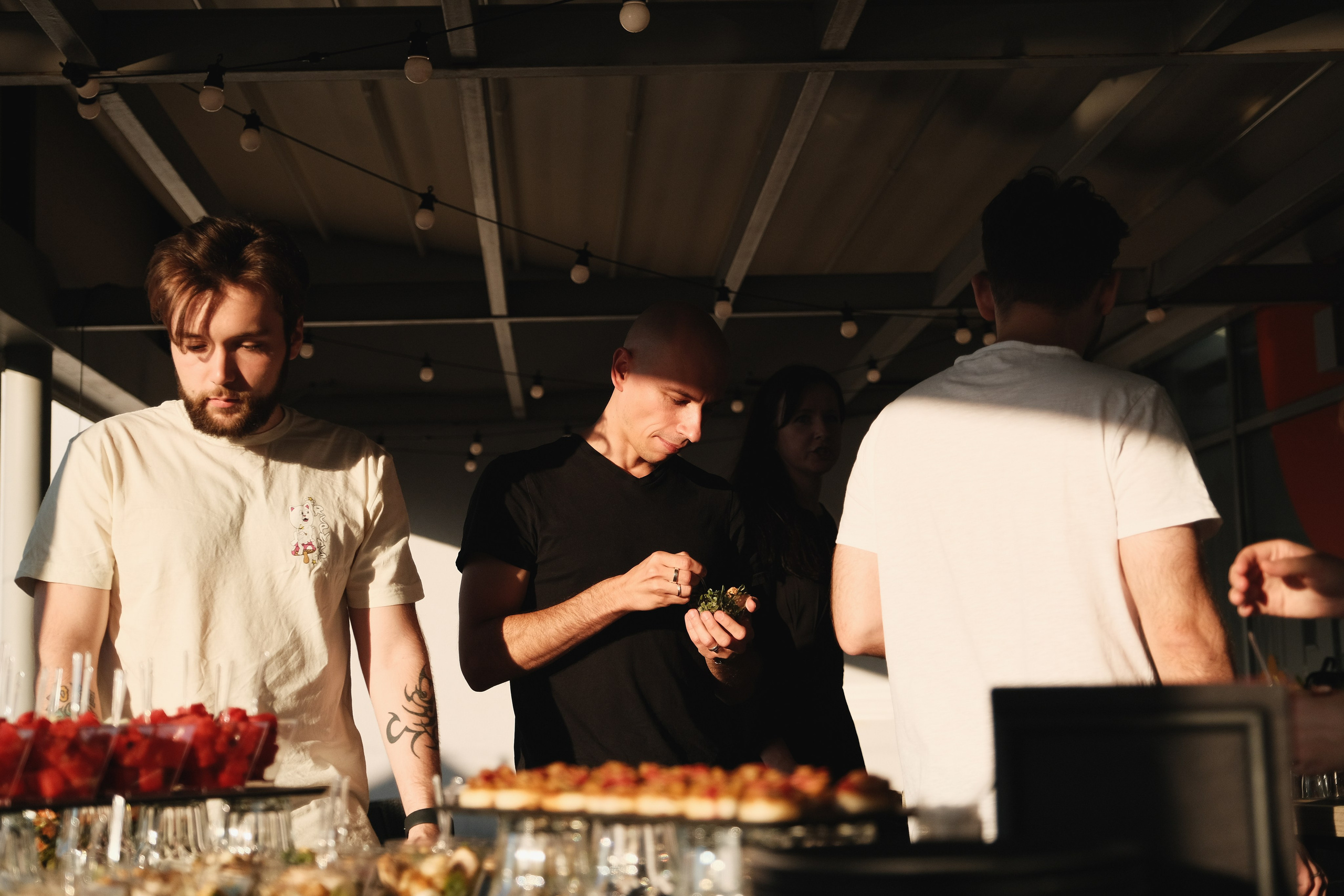 Люди подходят к фуршетному столу на корпоративной вечеринке.