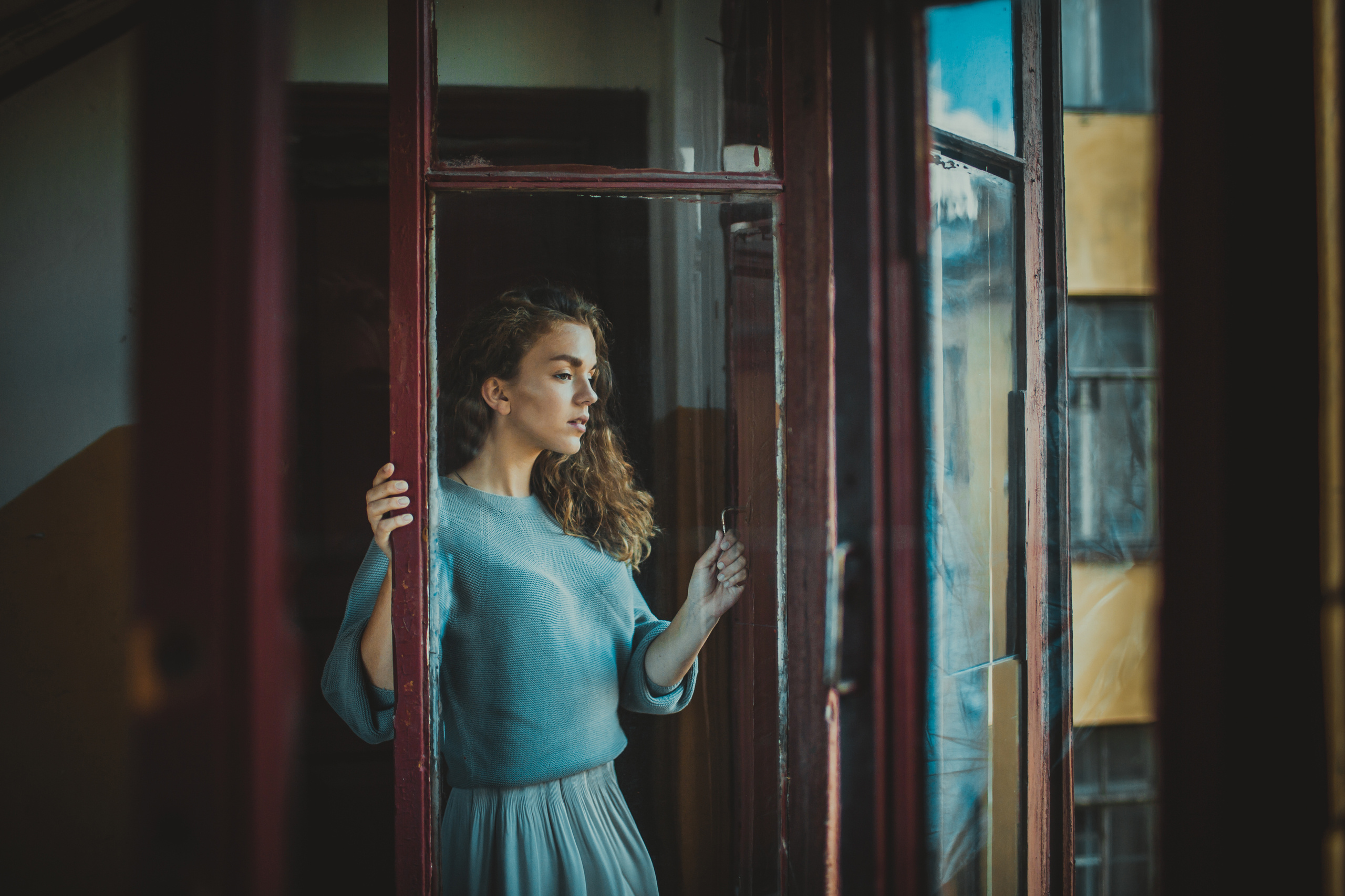томная девушка в голубом у открытого окна