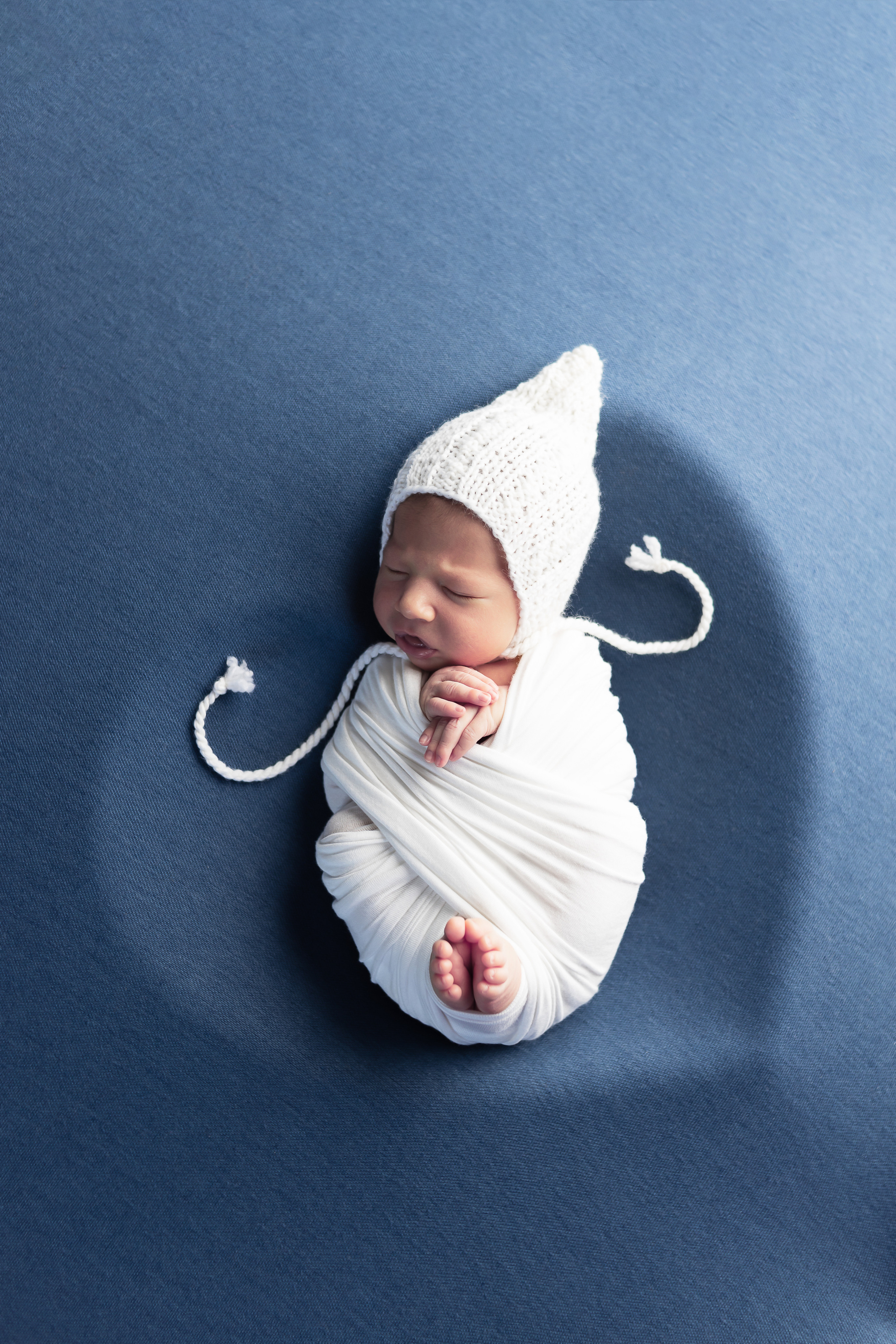 Кокон восьмерка на синем фоне в белой шапочке