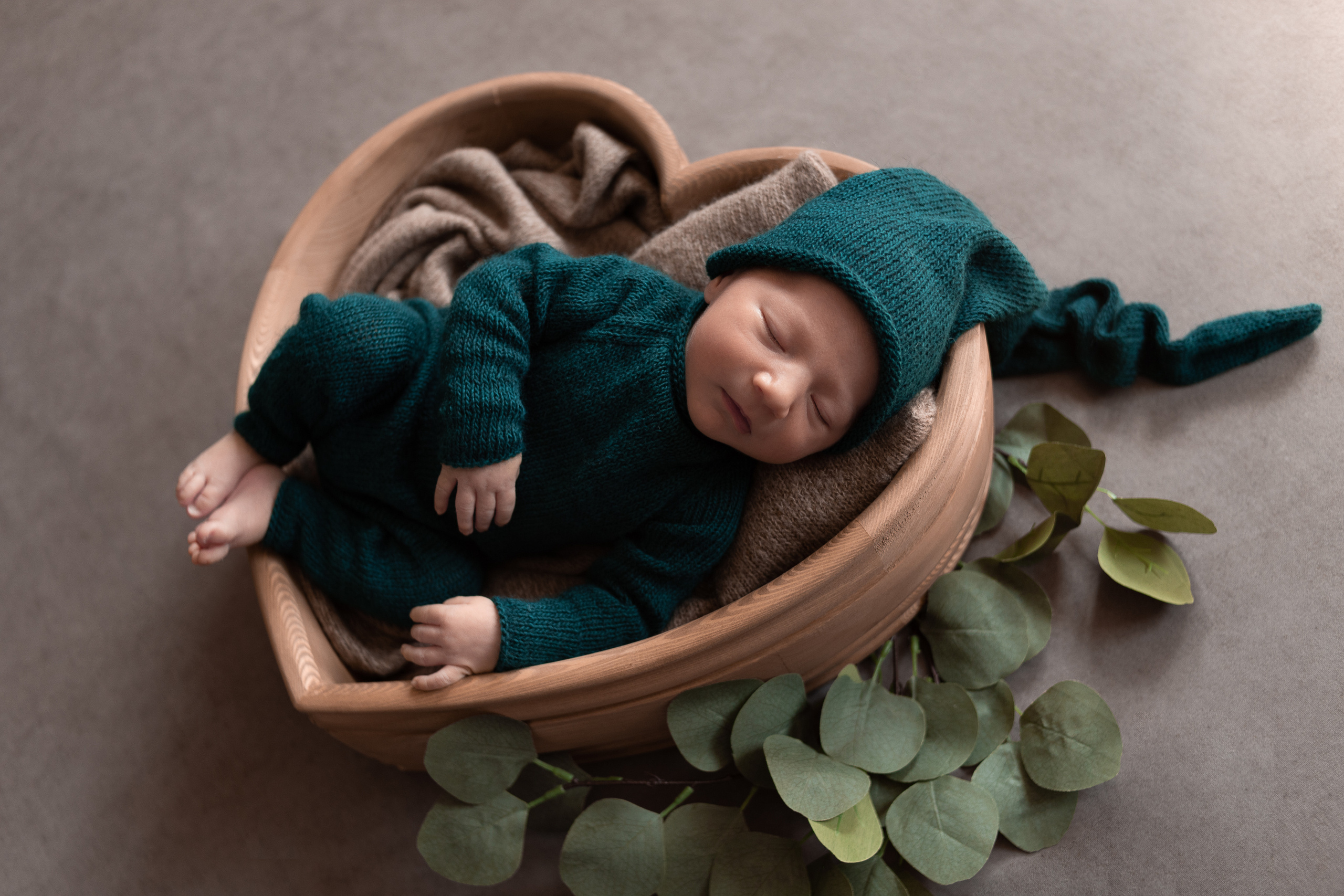 Сонный мальчик в зеленом костюме и шапочке гномика