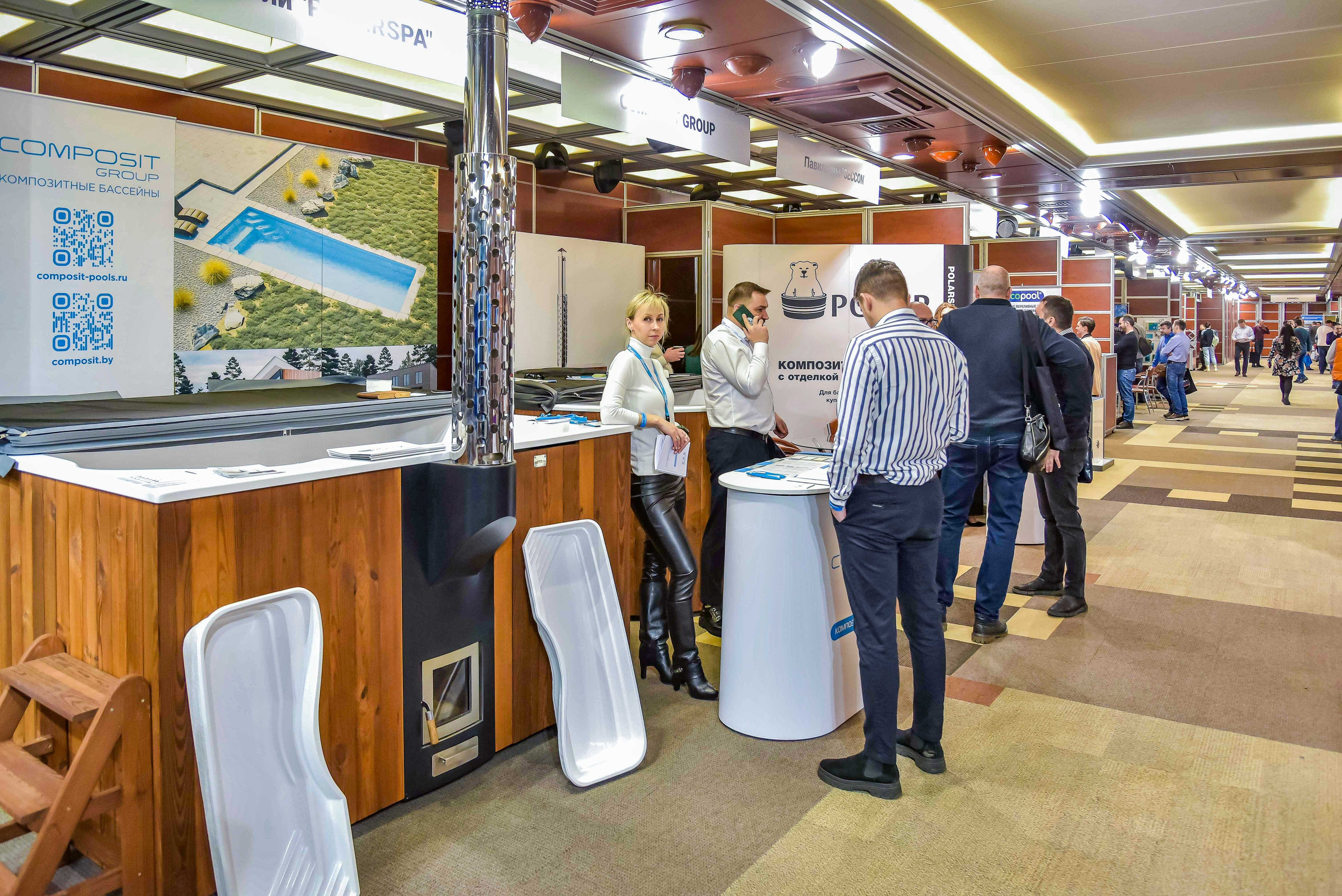 Репортажная съемка с выставки в Москве: снимок передаёт общение между представителем компании и посетителями выставки.