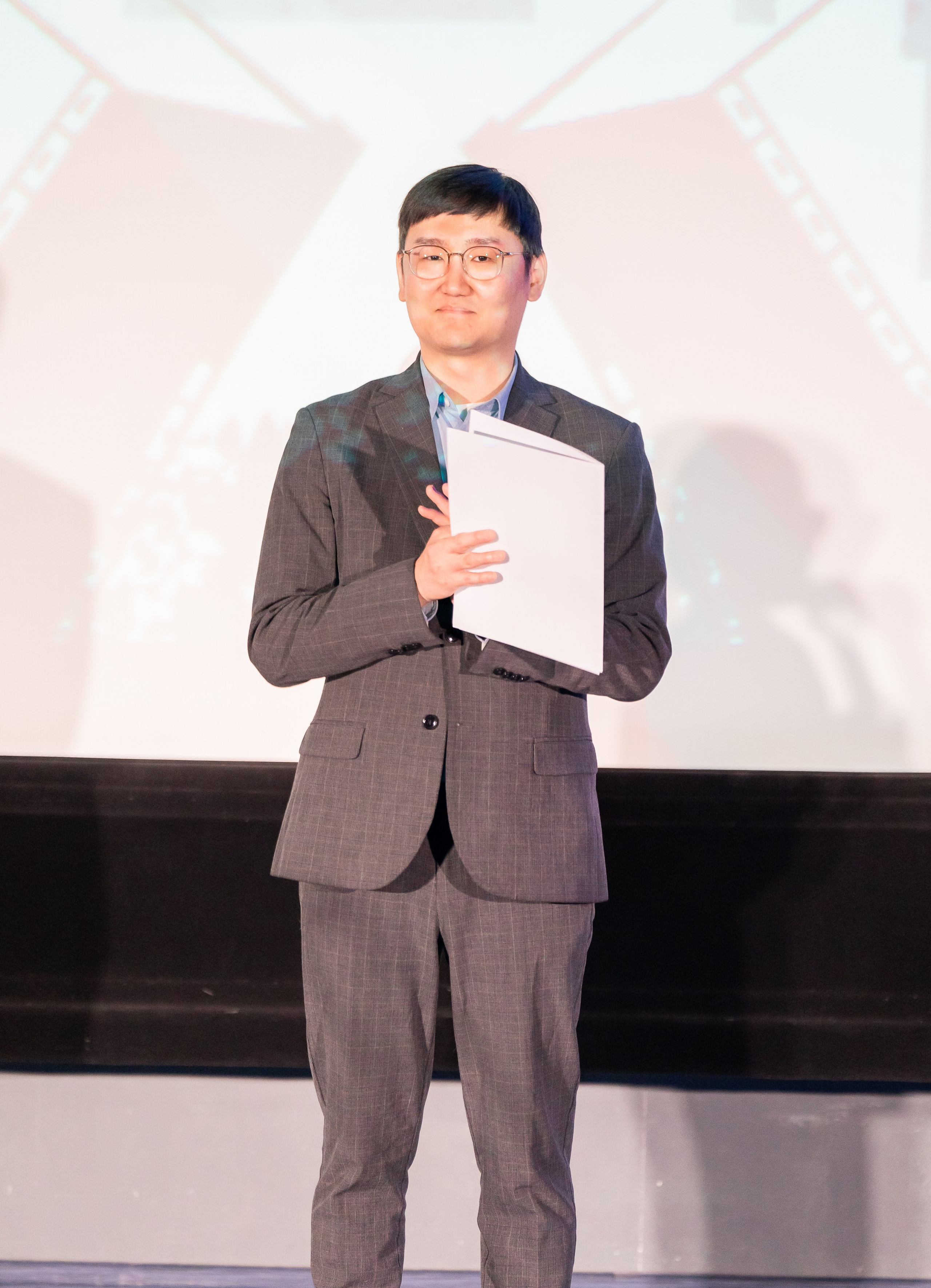 Представитель оргкомитета XII Международного фольклорного фестиваля «Сохраняем традиции» Санкт-Петербург 2026 на сцене с документами. Фото: Мальцев Евгений, evrednix.ru.