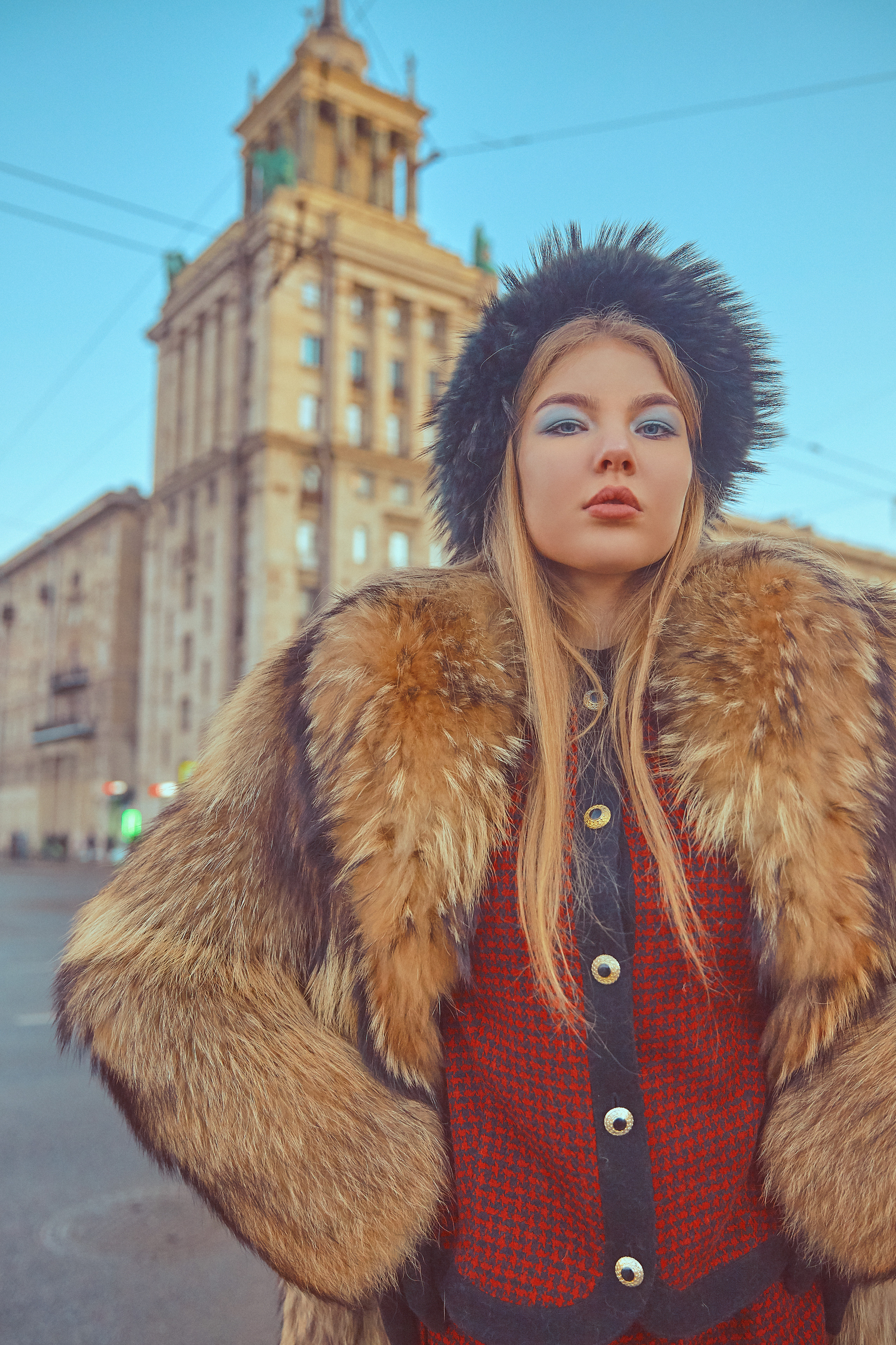 девушка в красном костюме и шубе на фоне советского здания зимой