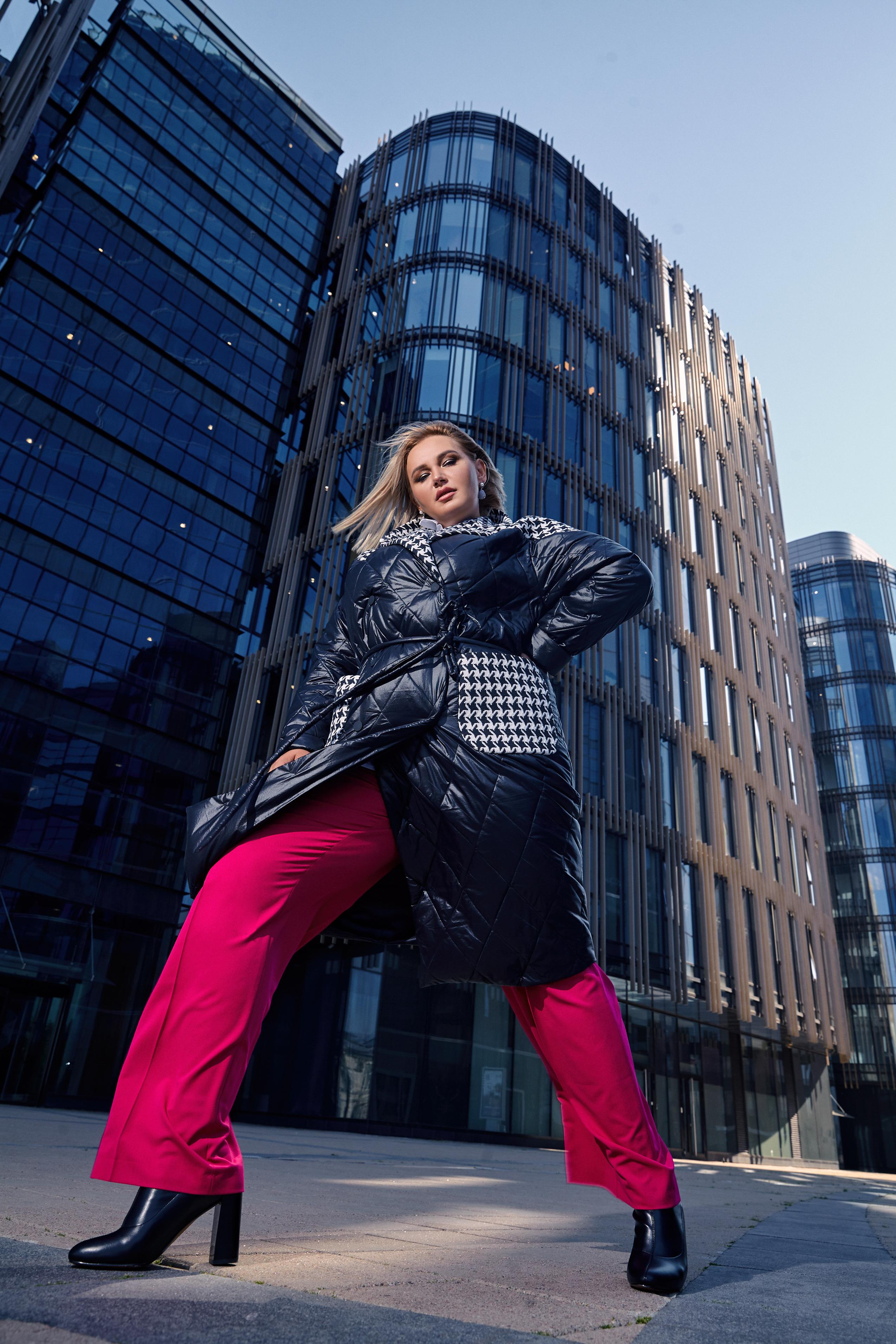 Плюссайз модель Светлана Жукова в зимней одежде Eva Graffova на фоне стеклянных зданий