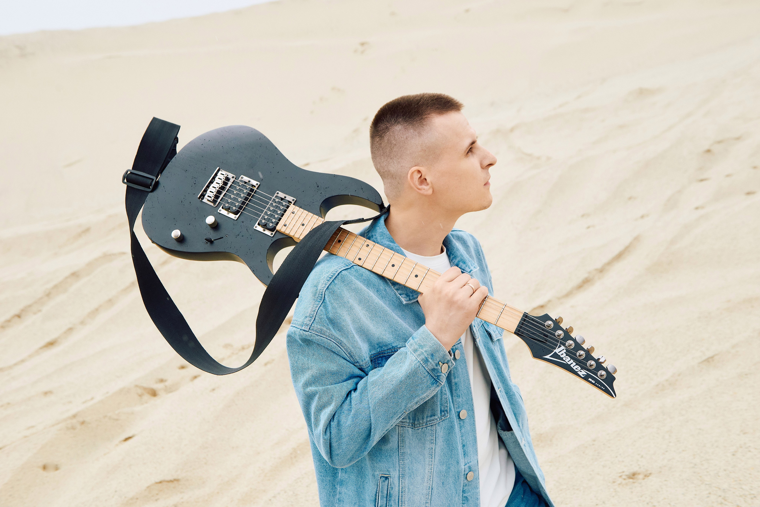 Парень играет на гитаре в пустыне