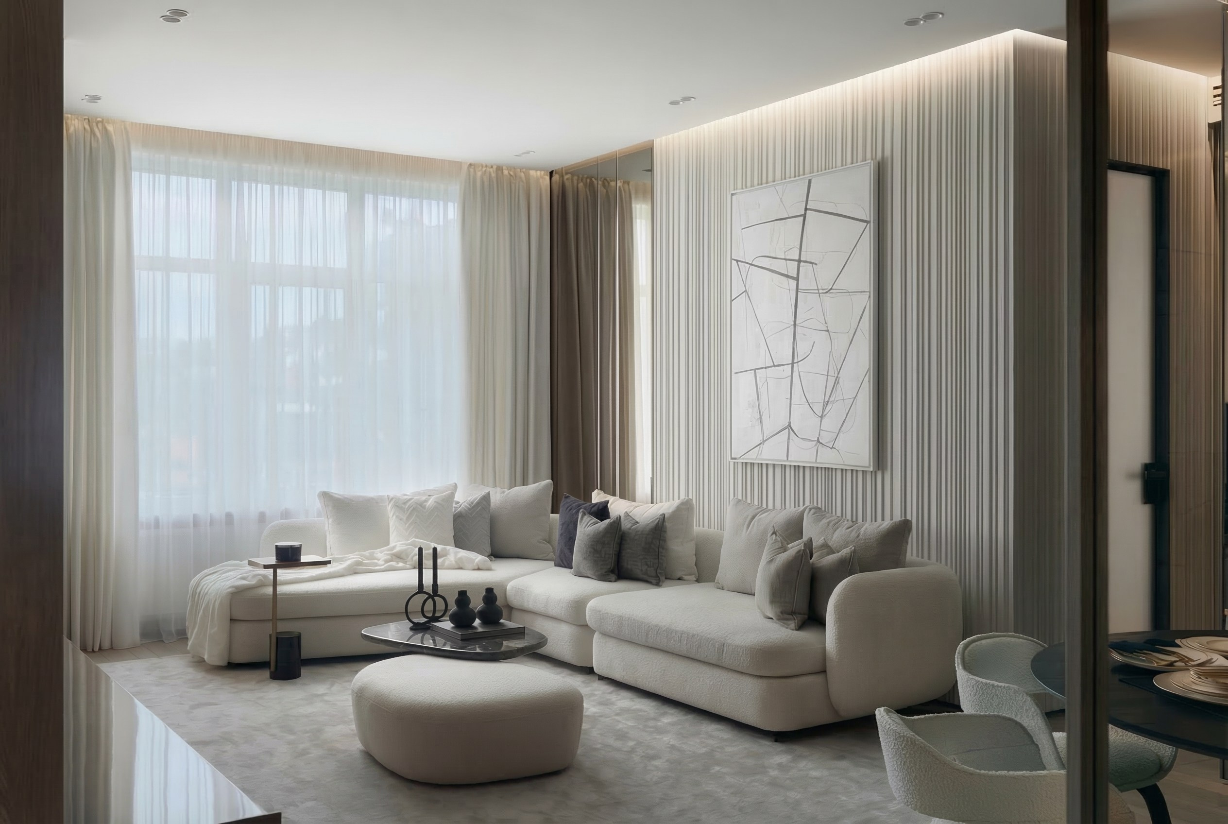 Современная гостиная от дизайнера Валерии Котович: большой угловой диван, декоративная стена с рейками и абстрактная картина в светлом интерьере.