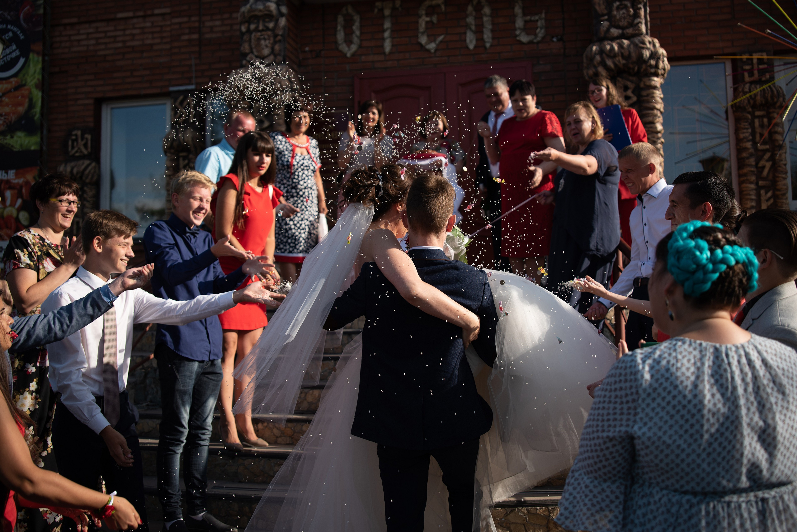 Жених на руках заносит невесту в банкетный зал.