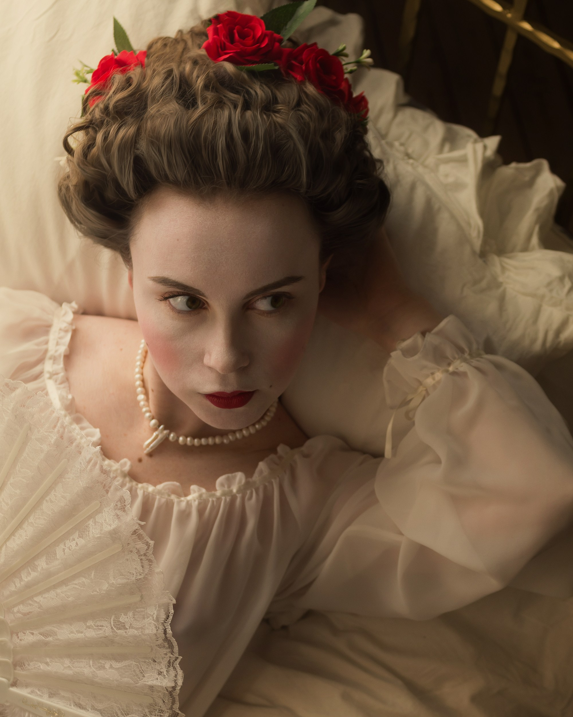 Женский портрет в ночной сорочке. Винтажный образ. Девушка со старинной прической лежит в кровати.