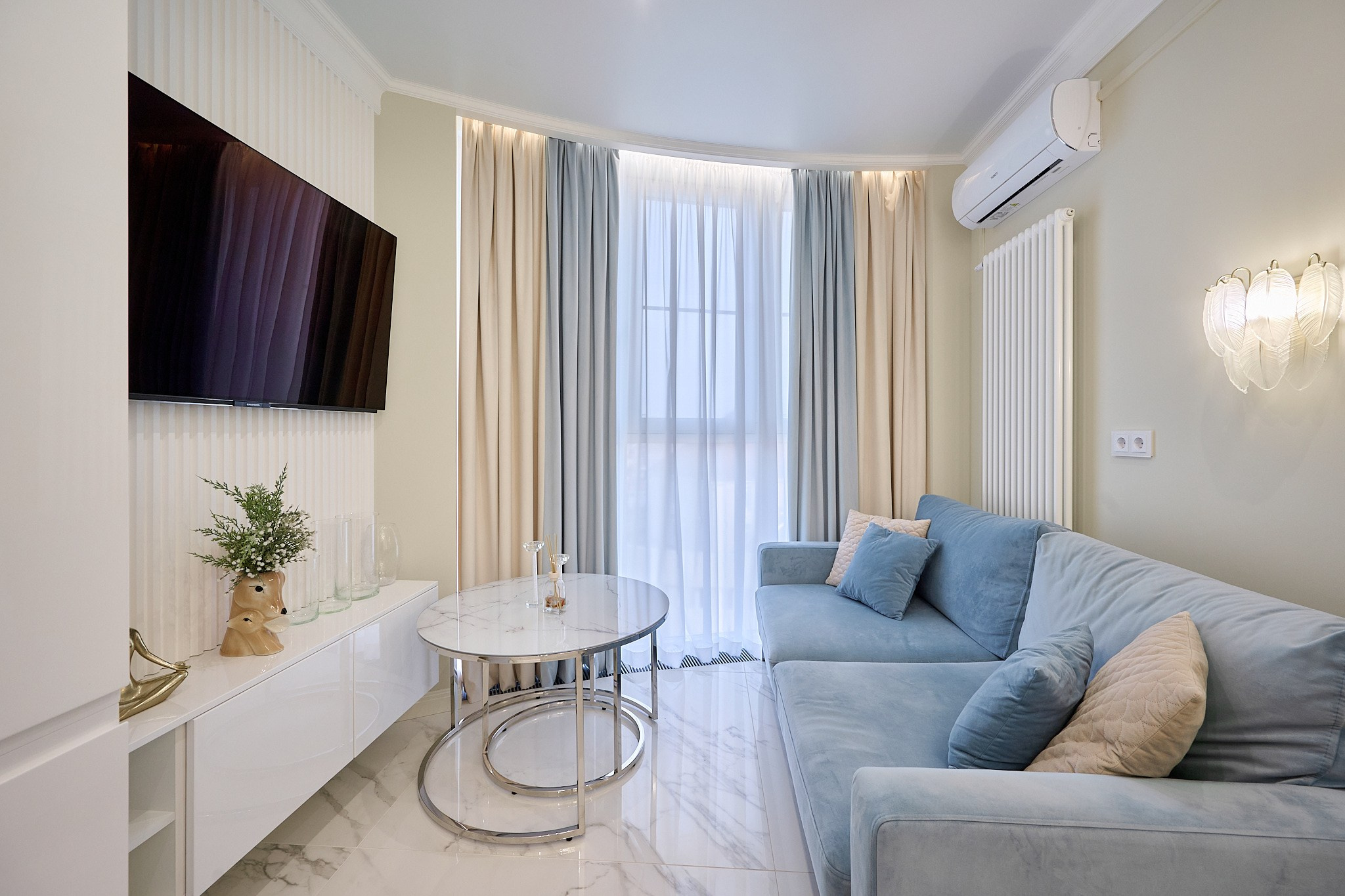 голубой диван полу прозрачный столик  телевизор 