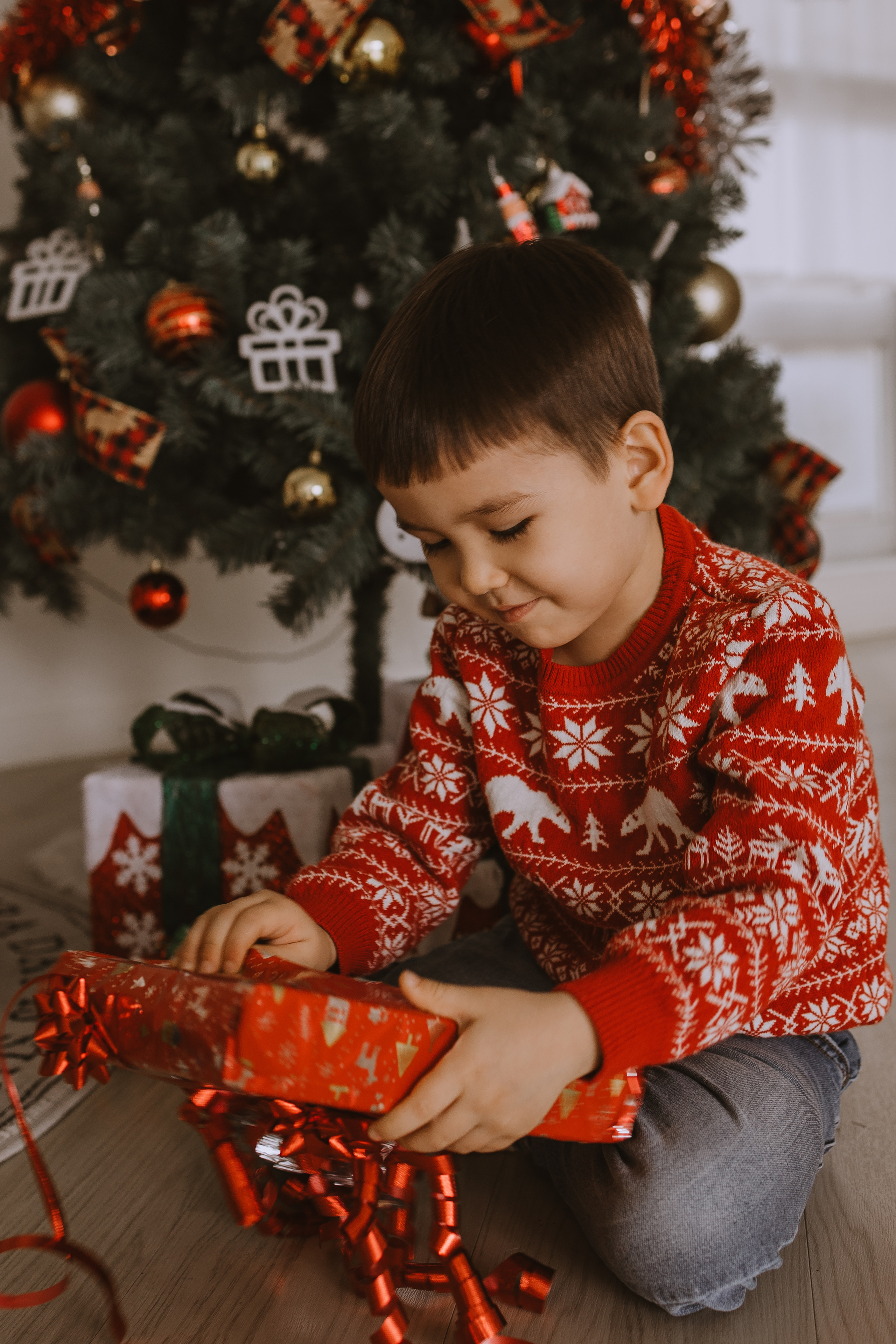 Сын открывает новогодний подарок под елкой в Корее 