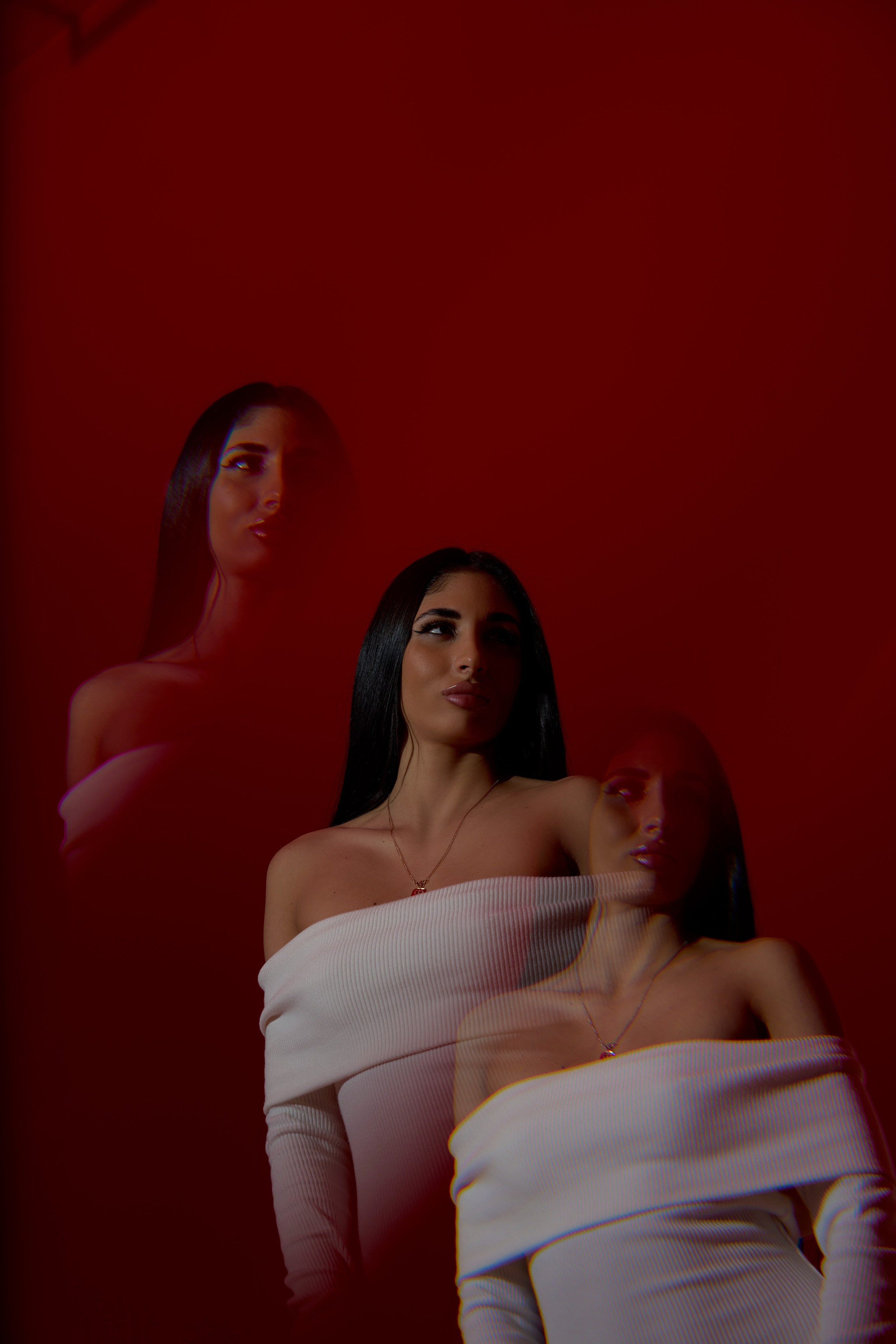 Арт-фотосессия в студии Москвы: девушка в белом платье, эффект двойного кадра, красный фон