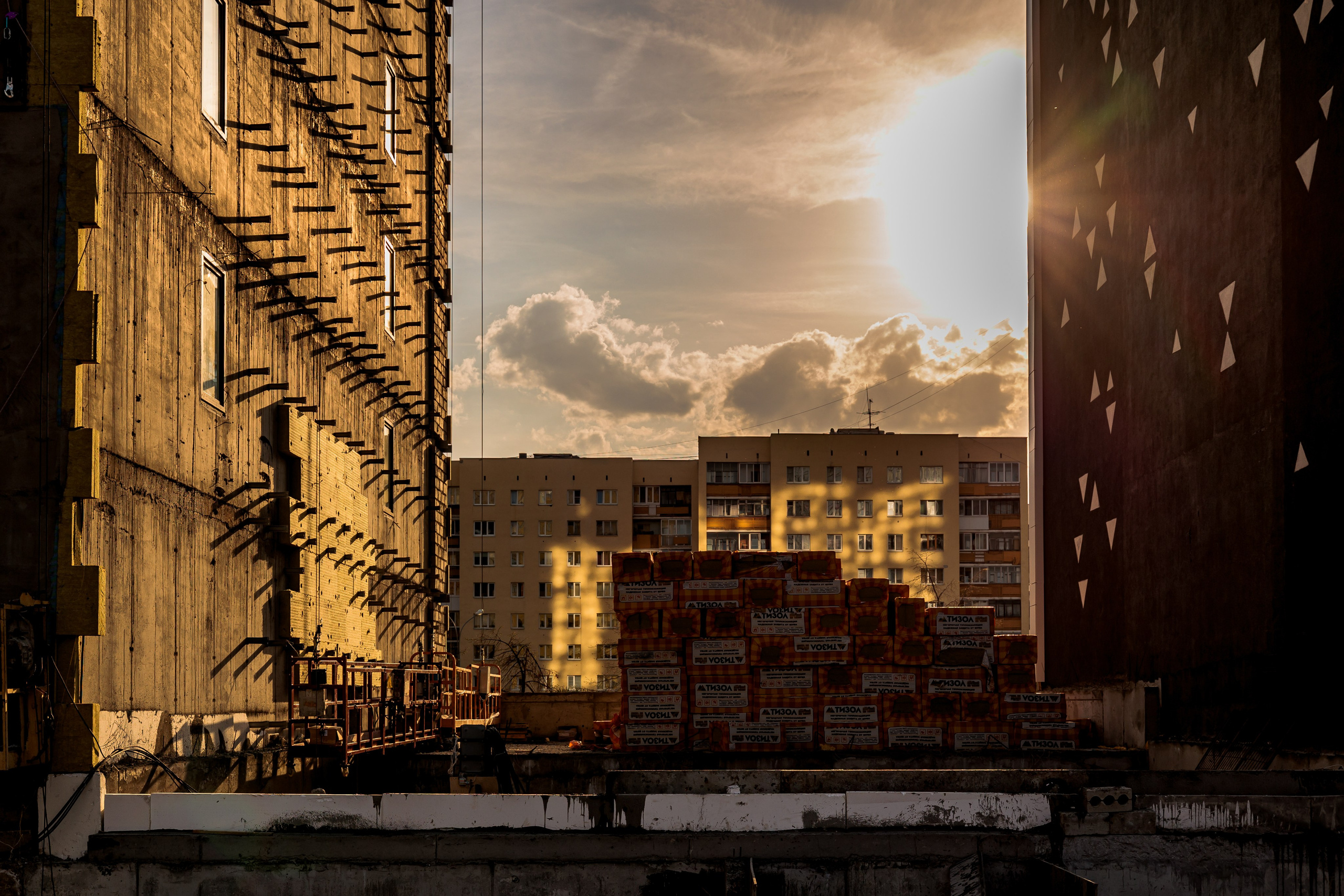 Архитектурная фотография современного небоскреба в Екатеринбурге. Отражение закатного света на стеклянном фасаде, вертикальные линии и геометрия высотного здания. Фотограф Илья Антропов.