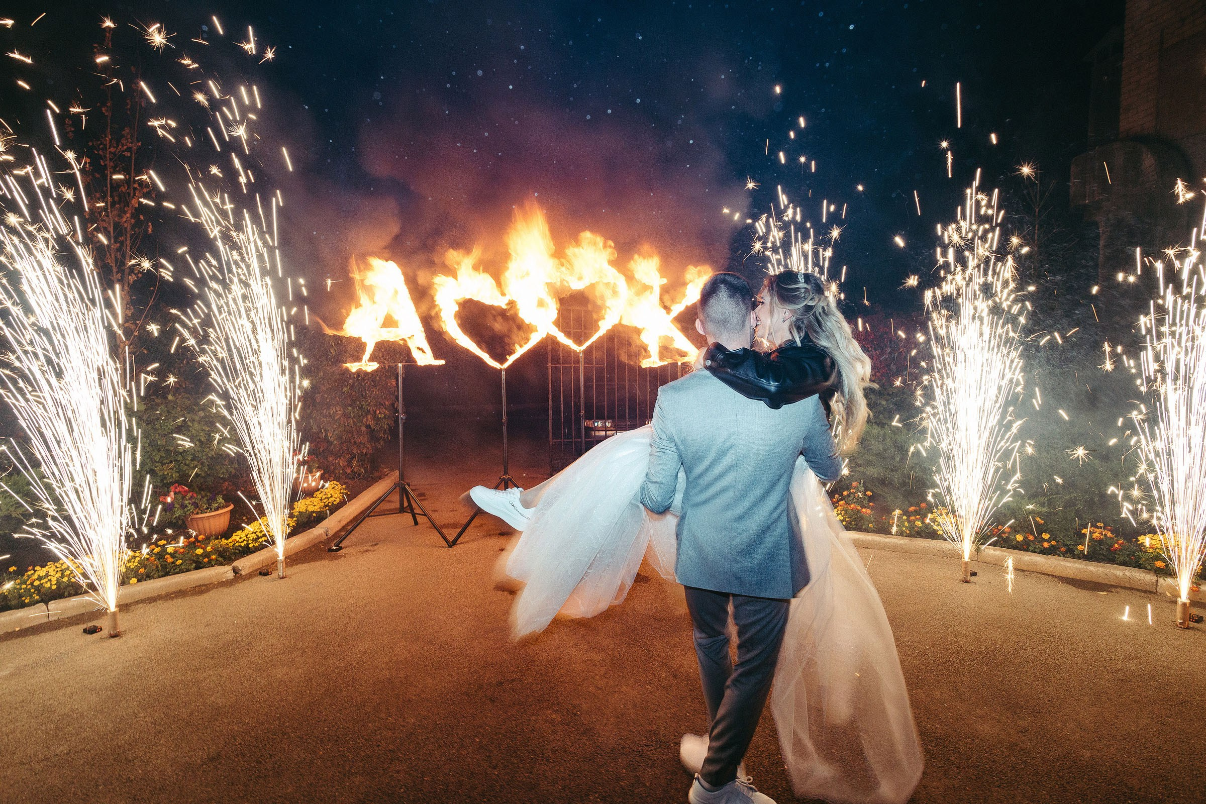 Жених кружит невесту на фоне горящих холодных фонтанов