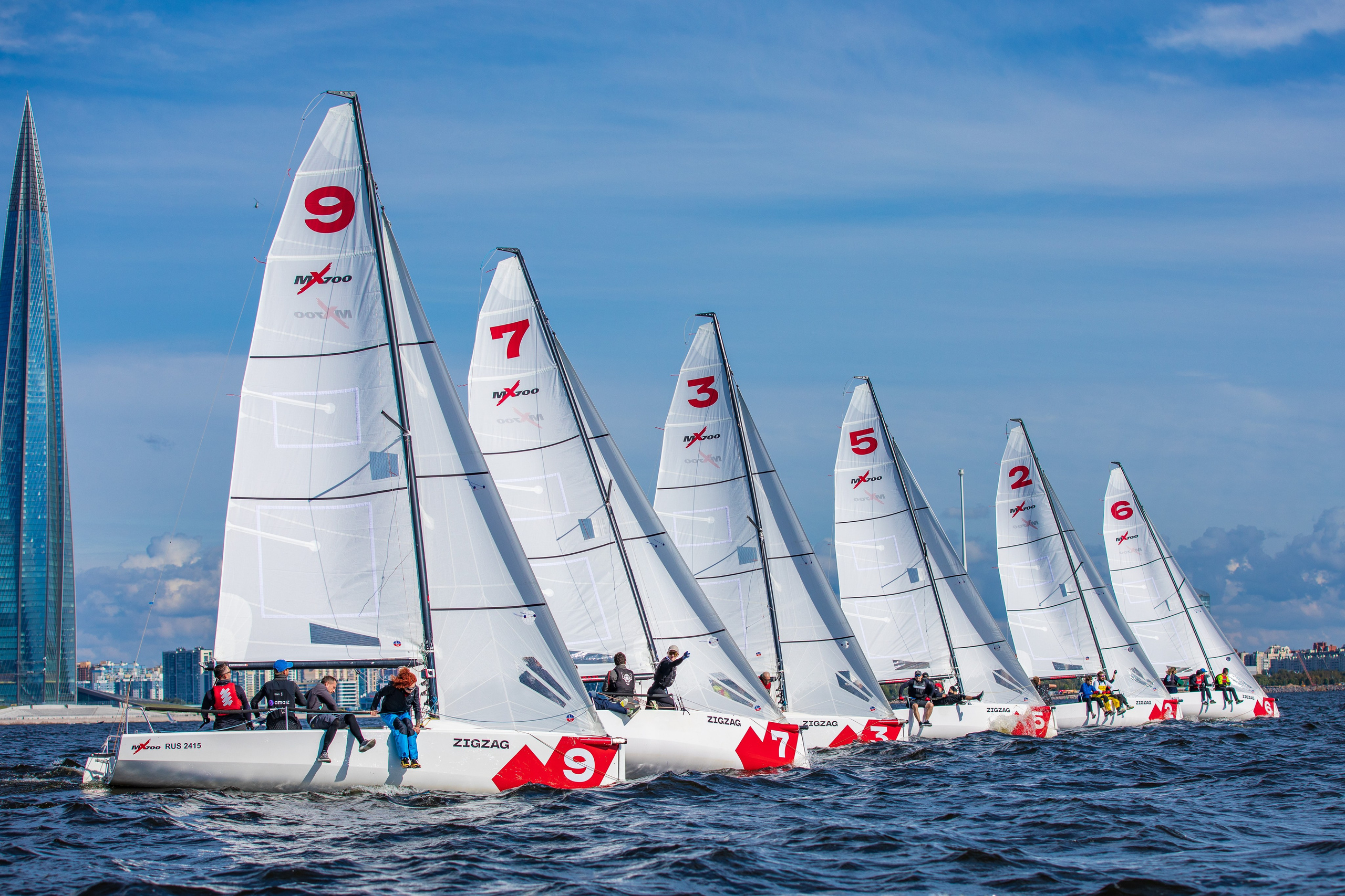 Яхты на стартовой линии на парусной регате на фоне Лахта центра.
