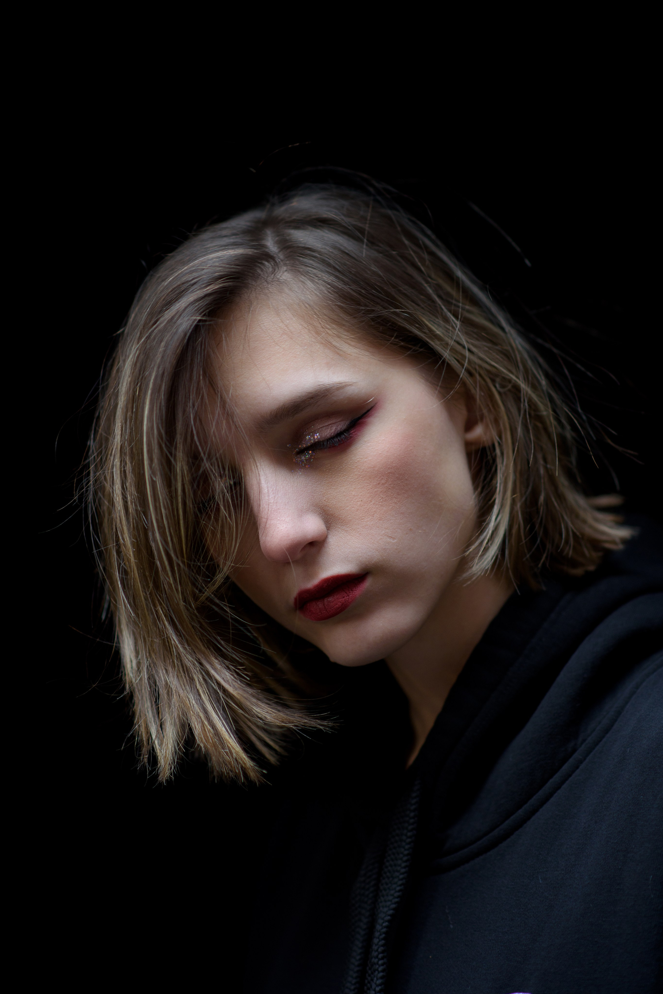 Фотосессия на 18тилетие на территории Красного октября в черной толстовке, крупный план с закрытыми глазами 