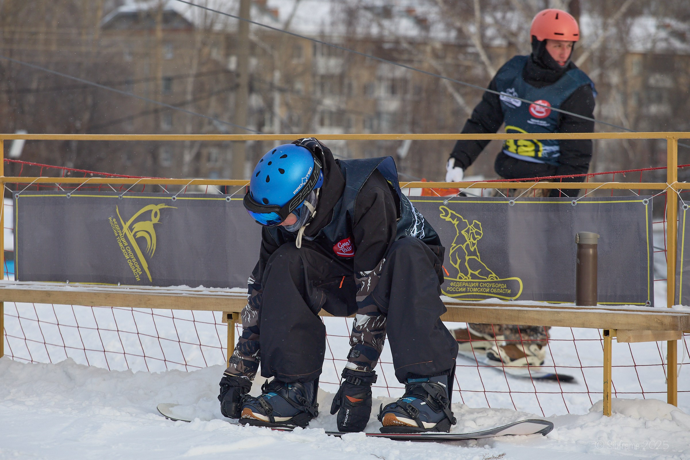 Сноубордист застегивает стрэпы