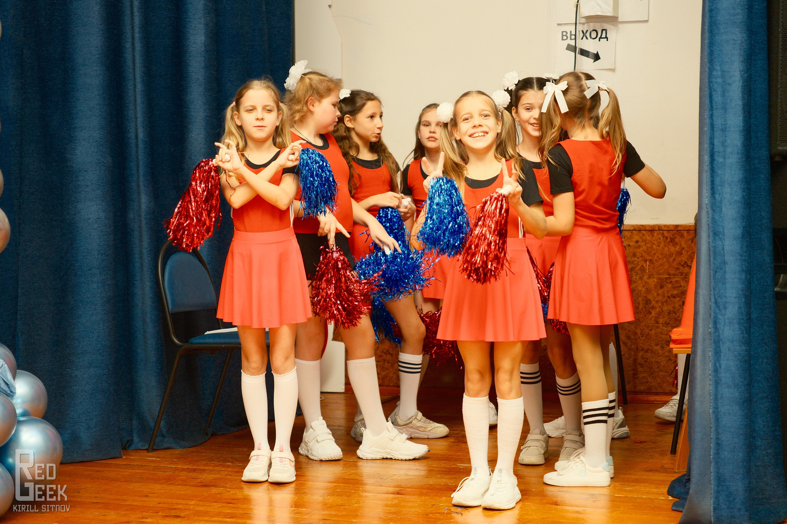 Школьницы за кулисами готовятся к выступлению с народным танцем.