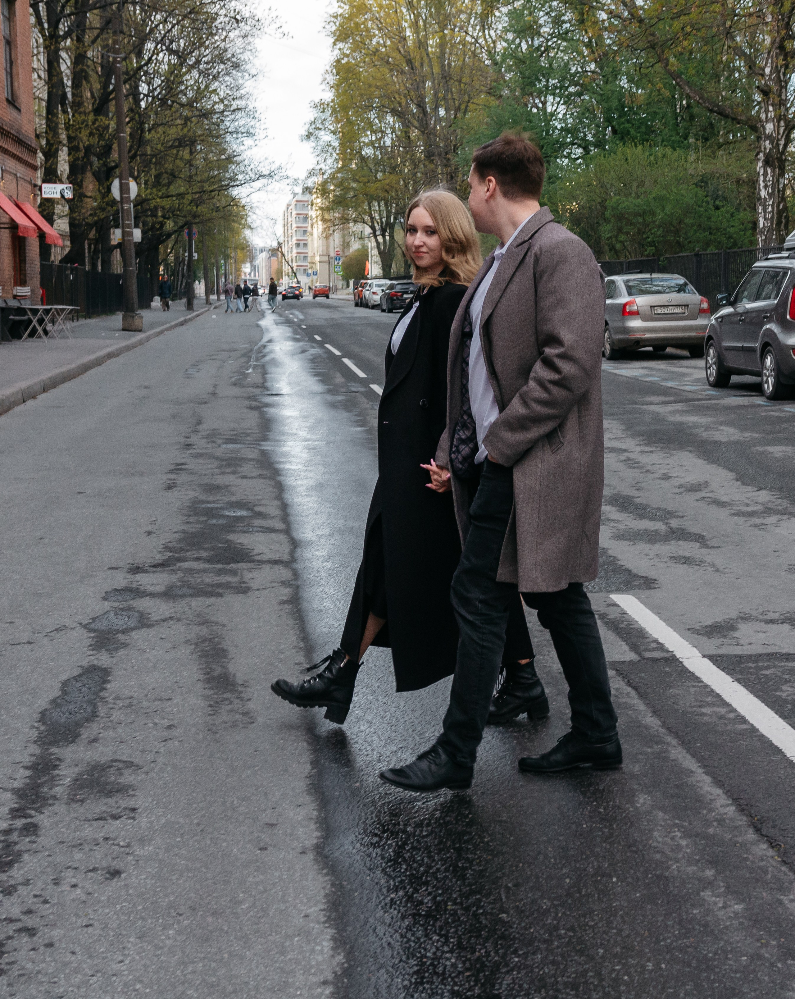 за руки пара переходит дорогу и бежит