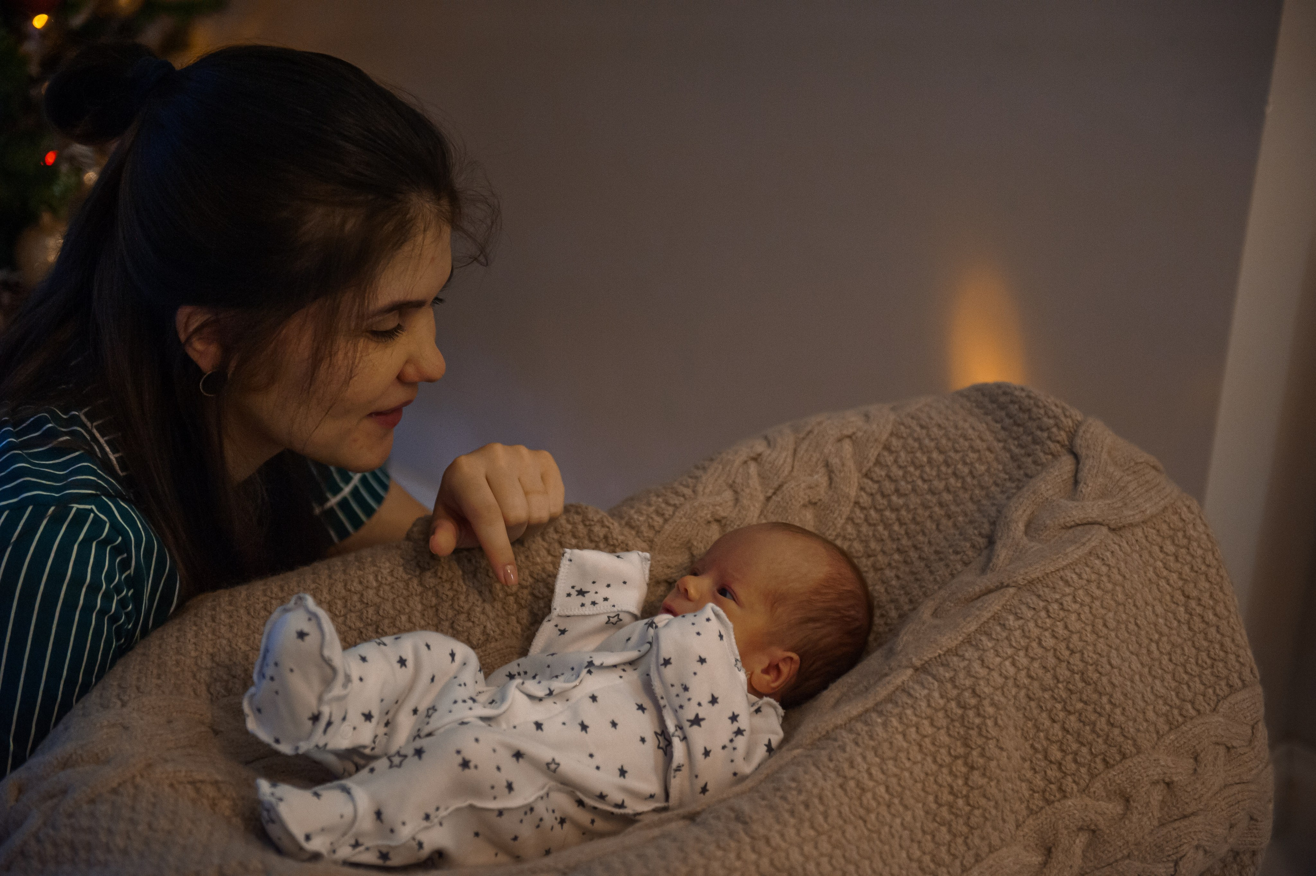 мама смотрит на своего новорожденного ребенка