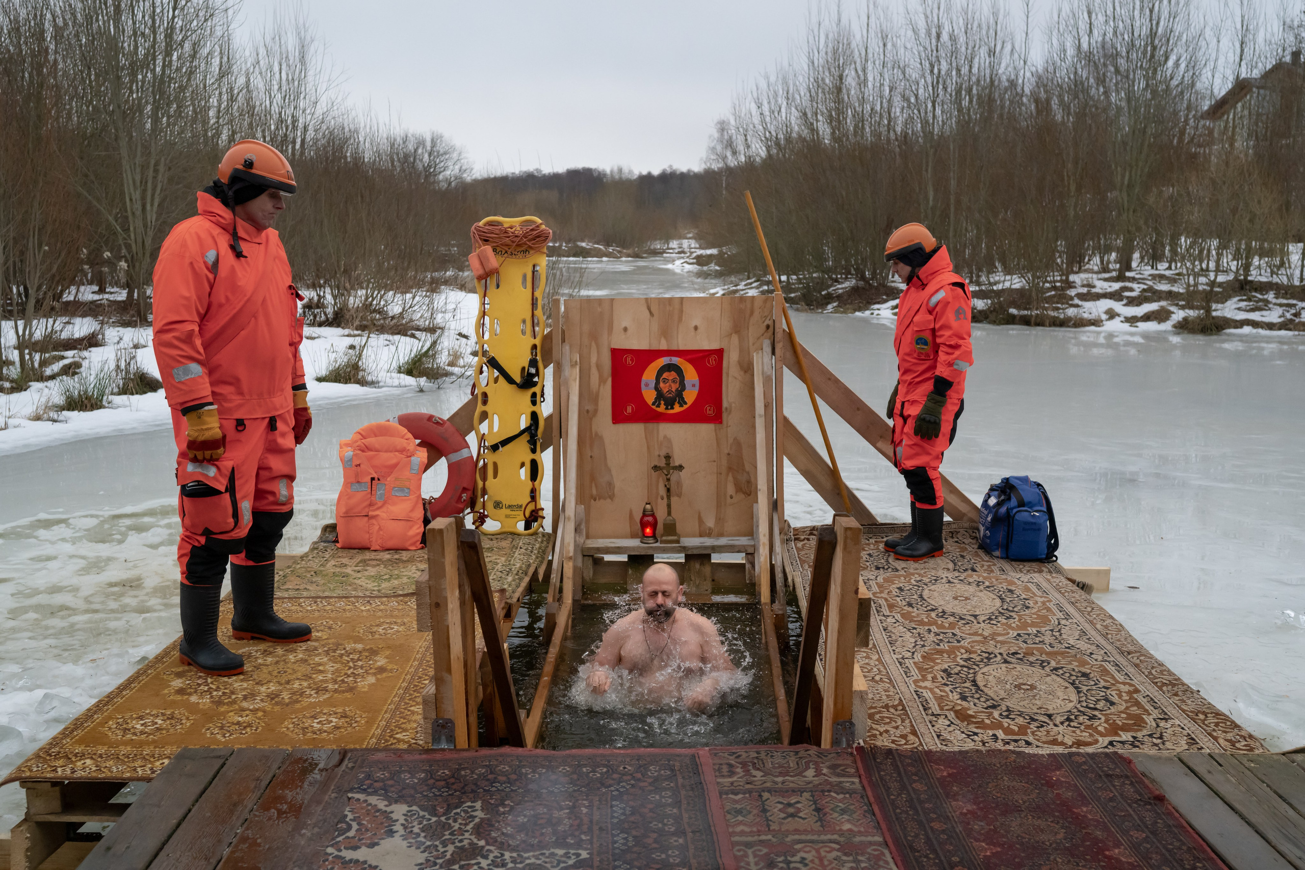 A rescuer watches as a Russian Orthodox believer plunges into icy water to celebrate the Orthodox Epiphany at a hole in a lake. St. Petersburg, January 18, 2025.