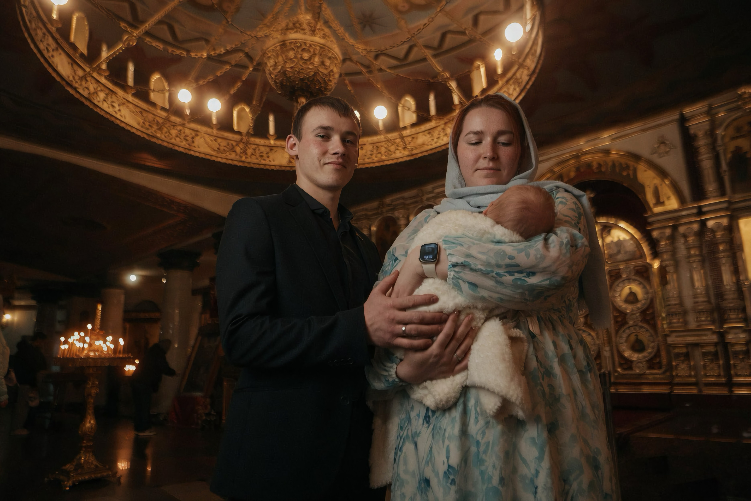 Молодые родители с новорождённым в храме, золотое паникадило и иконостас — Екатеринбург, Илья Антропов​​​​​​​​​​​​​​​​
