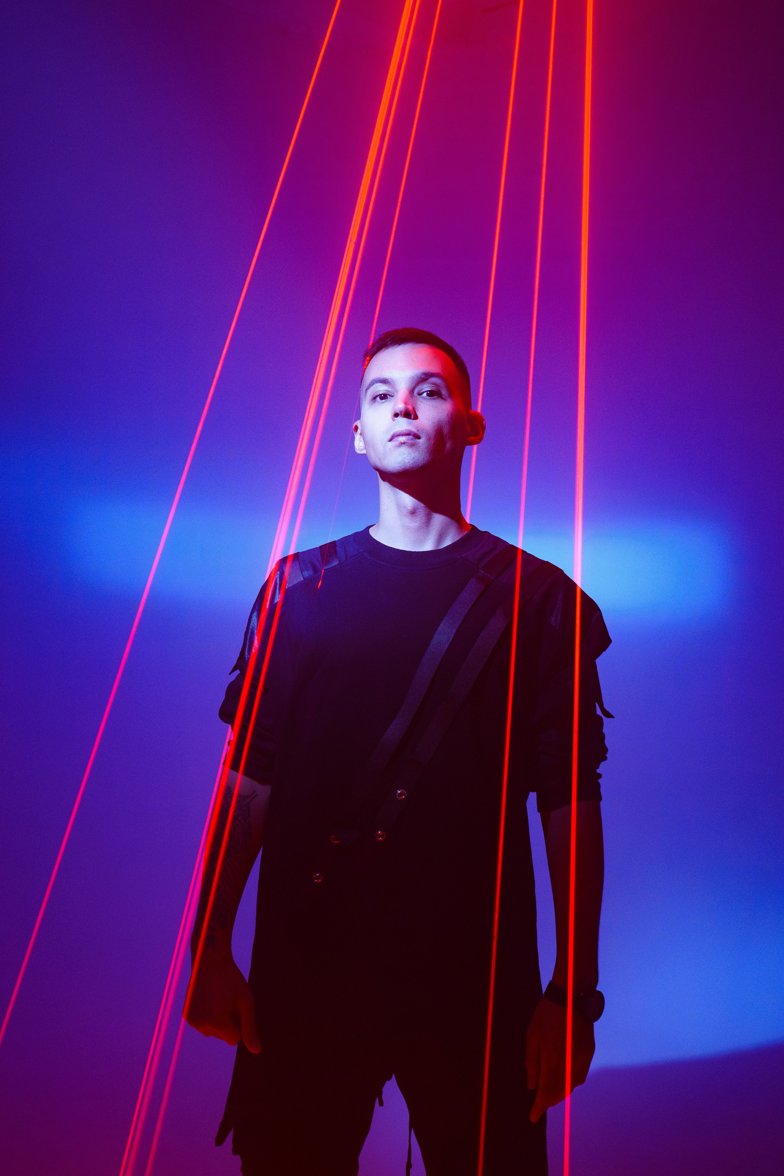 Портрет мужчины в лазерном свете с красно-синим фоном