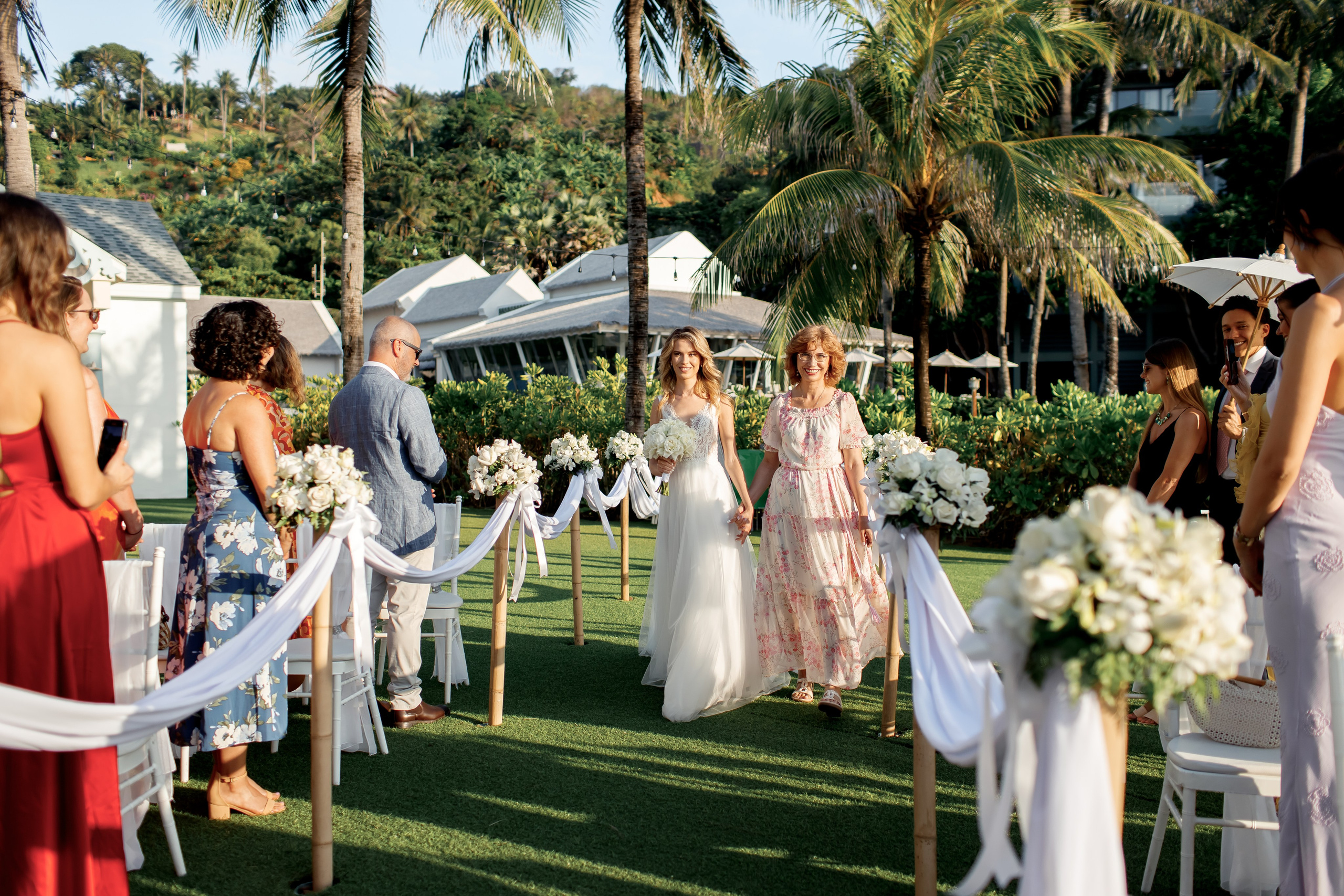 невеста с мамой идет по тропинке к арке