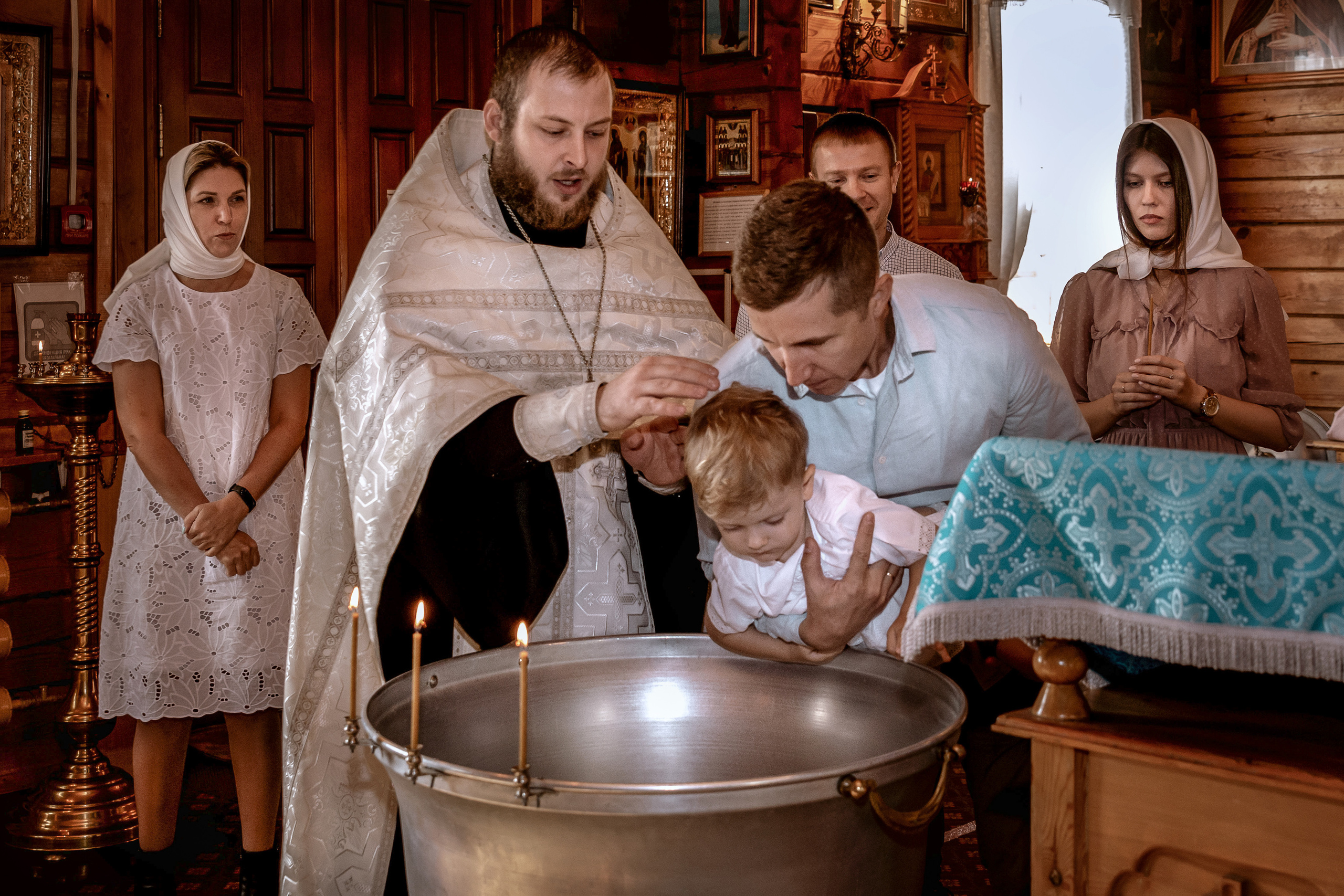 Погружение малыша в купель. Окропление святой водой на таинстве Крещения.