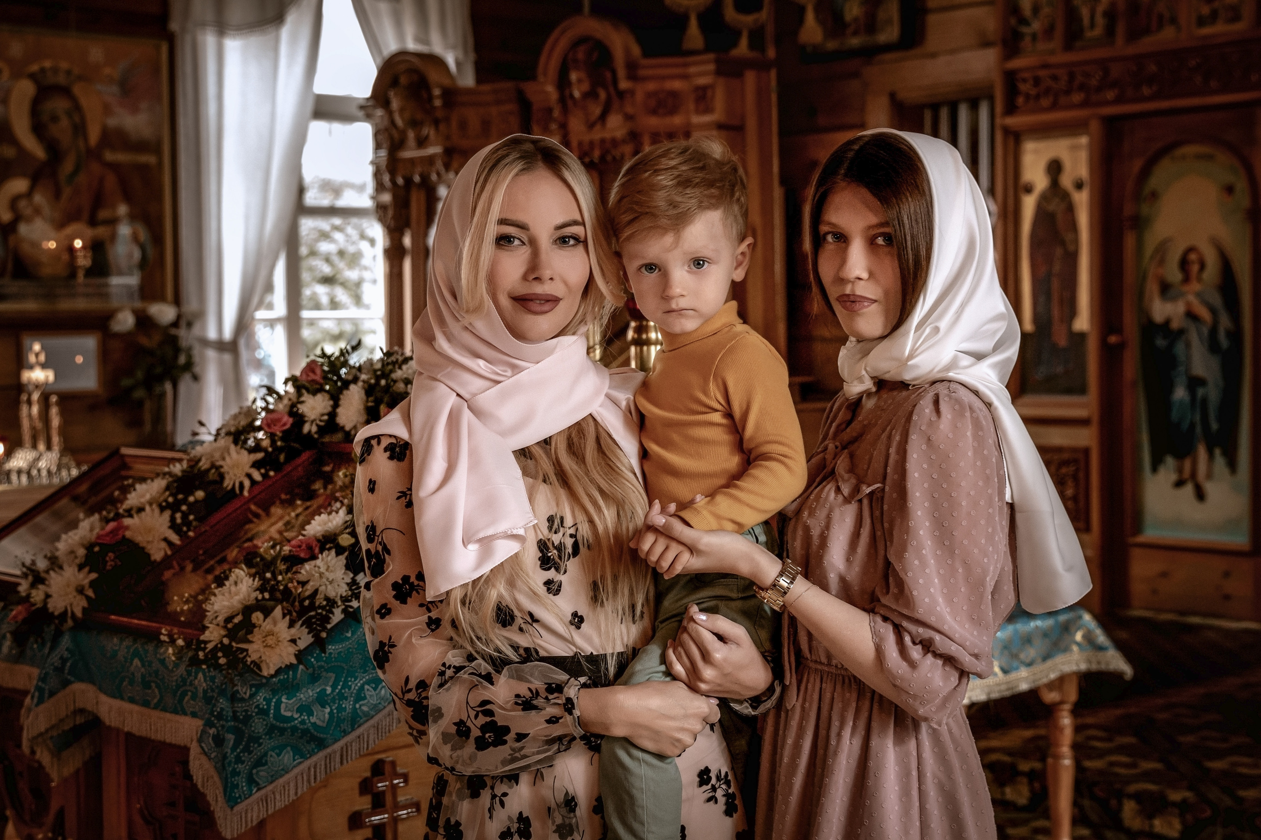 Мама, крестная и ребенок в храме.