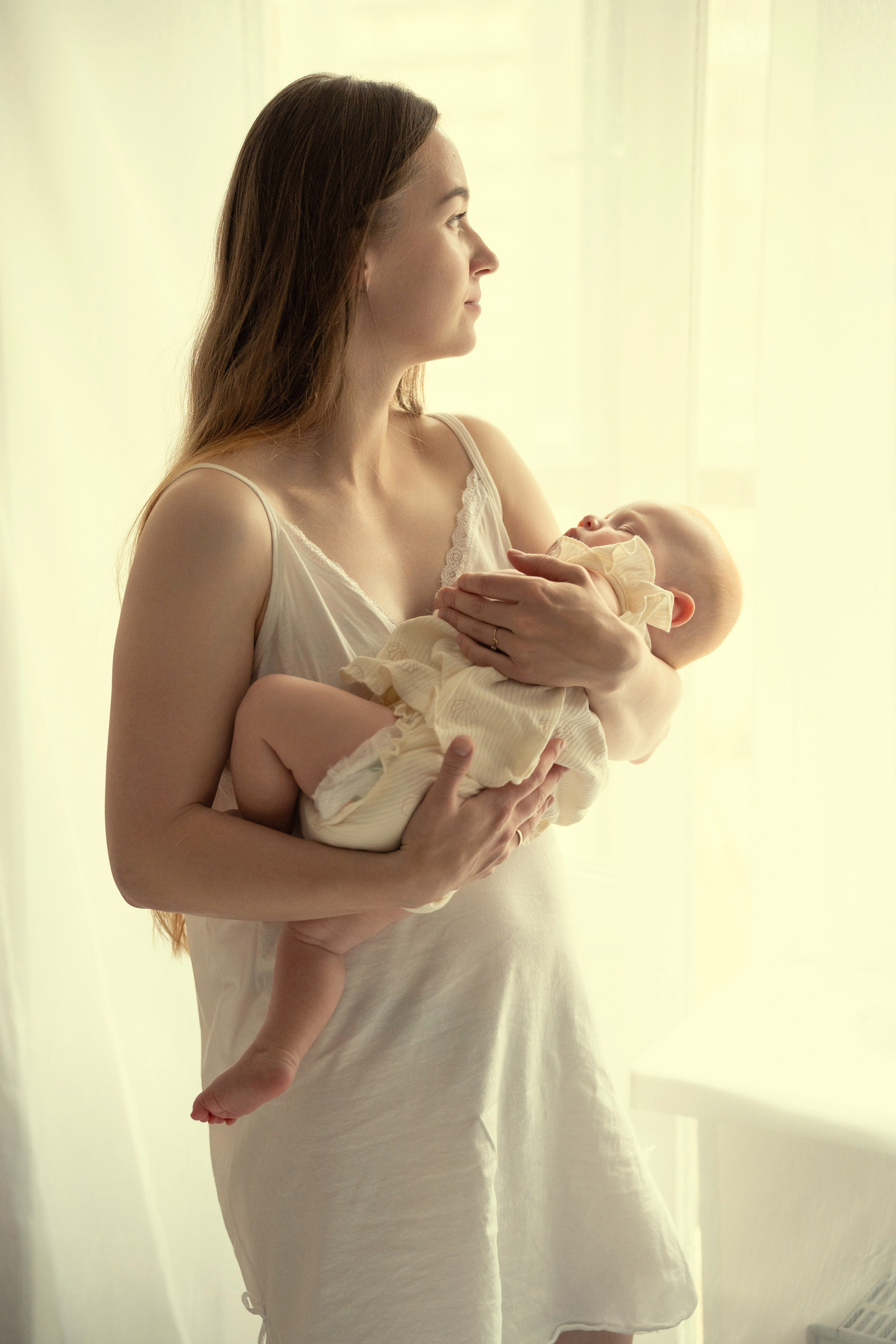 Молодая мама убаюкивает своего ребенка.