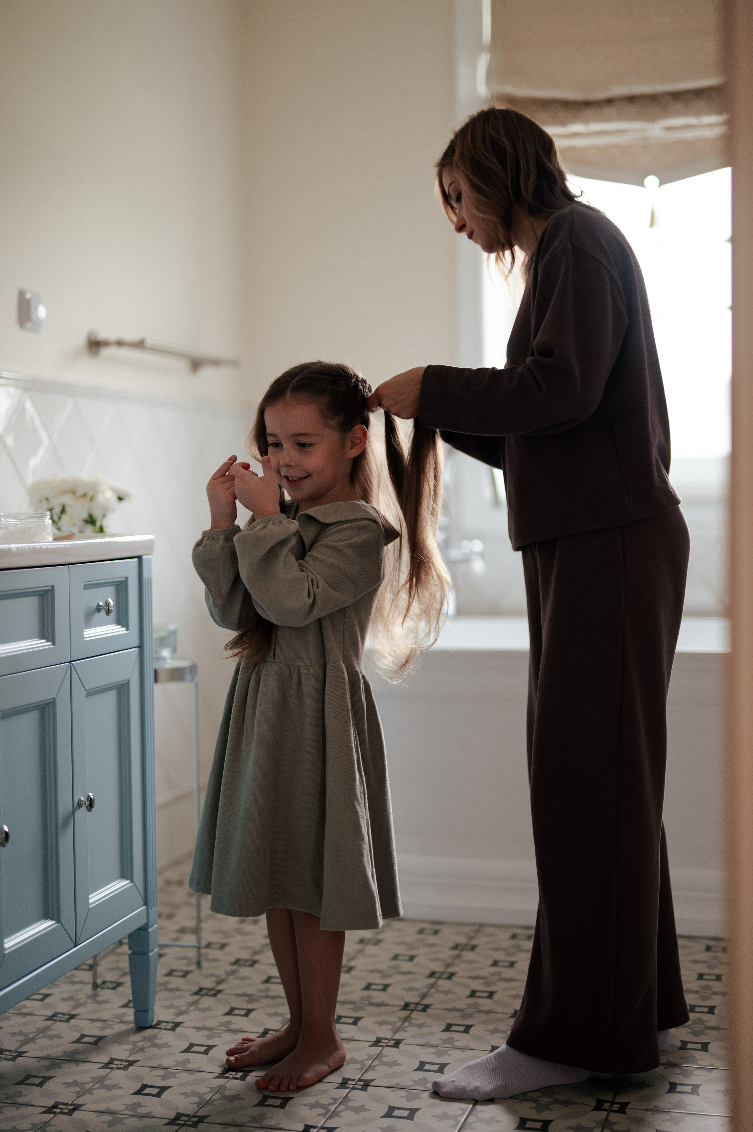 семейная фотосессия, мама заплетает косички дочке