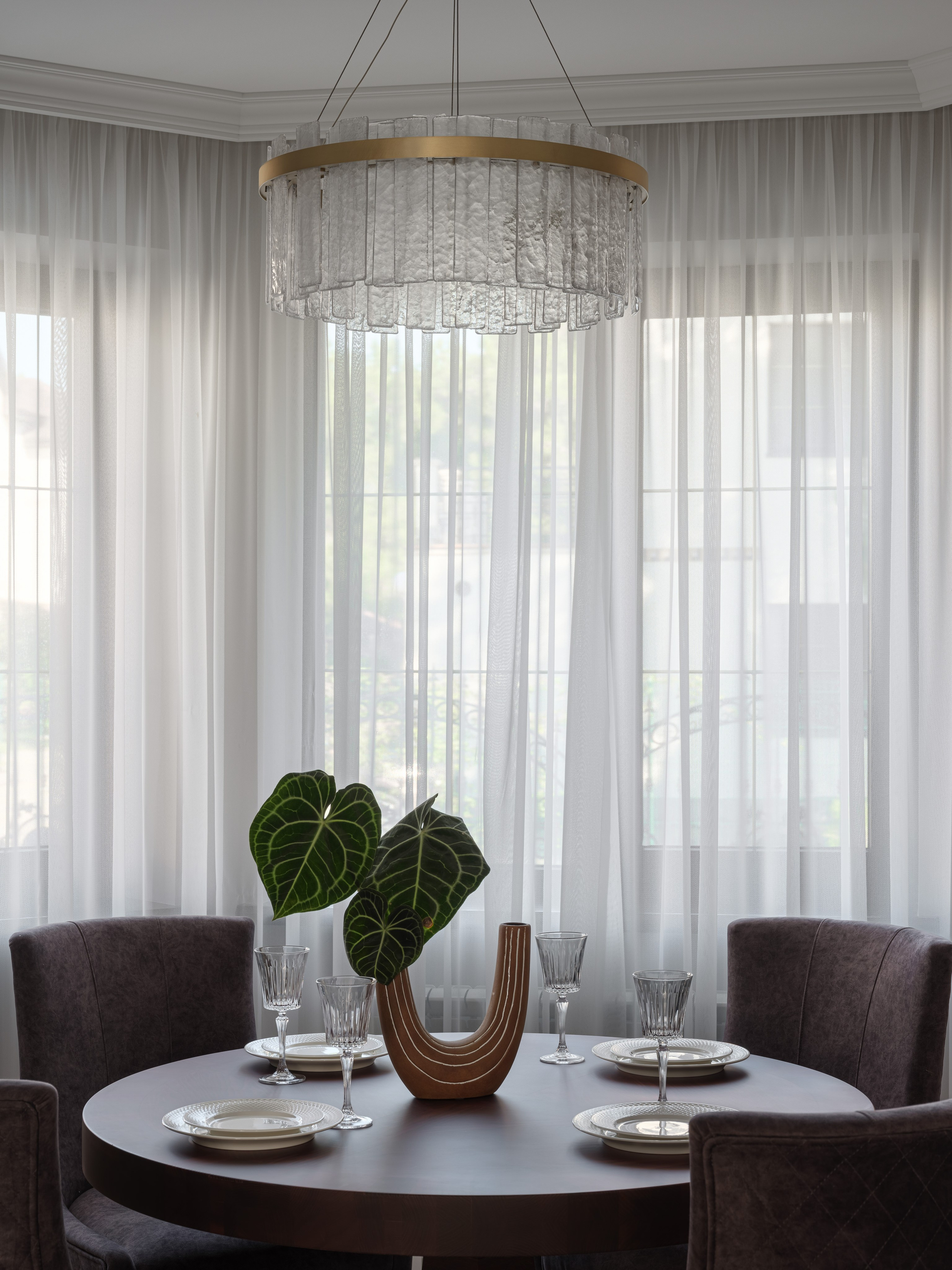 Современный стиль интерьера кухни-столовой с дизайнерской люстрой, элегантной сервировкой и зелеными акцентами в вазе. Интерьер Татьяны Диденко, фотосъемка Сергея Денисенко, стилизация Натальи Якушевой.