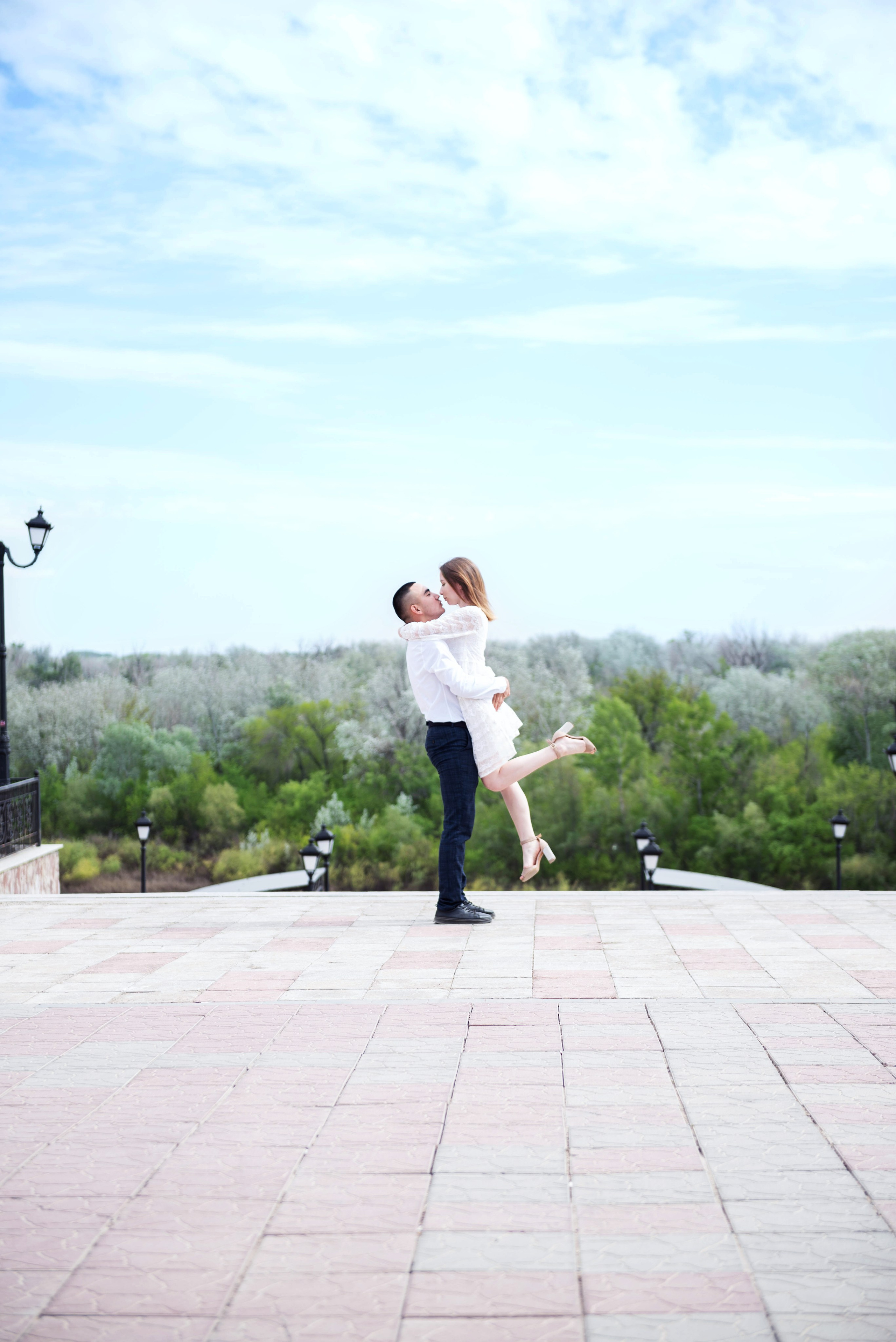 Влюбленная пара целуется на набережной.