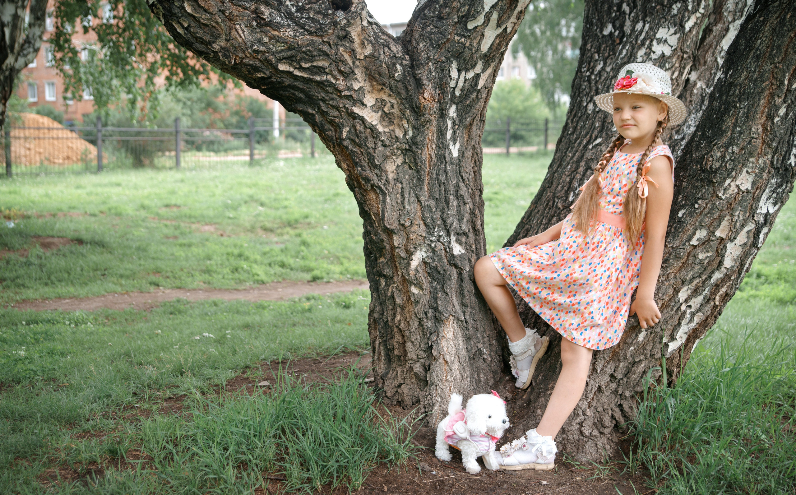 Детская фотосессия летом - девочка стоя у дерева со щенком