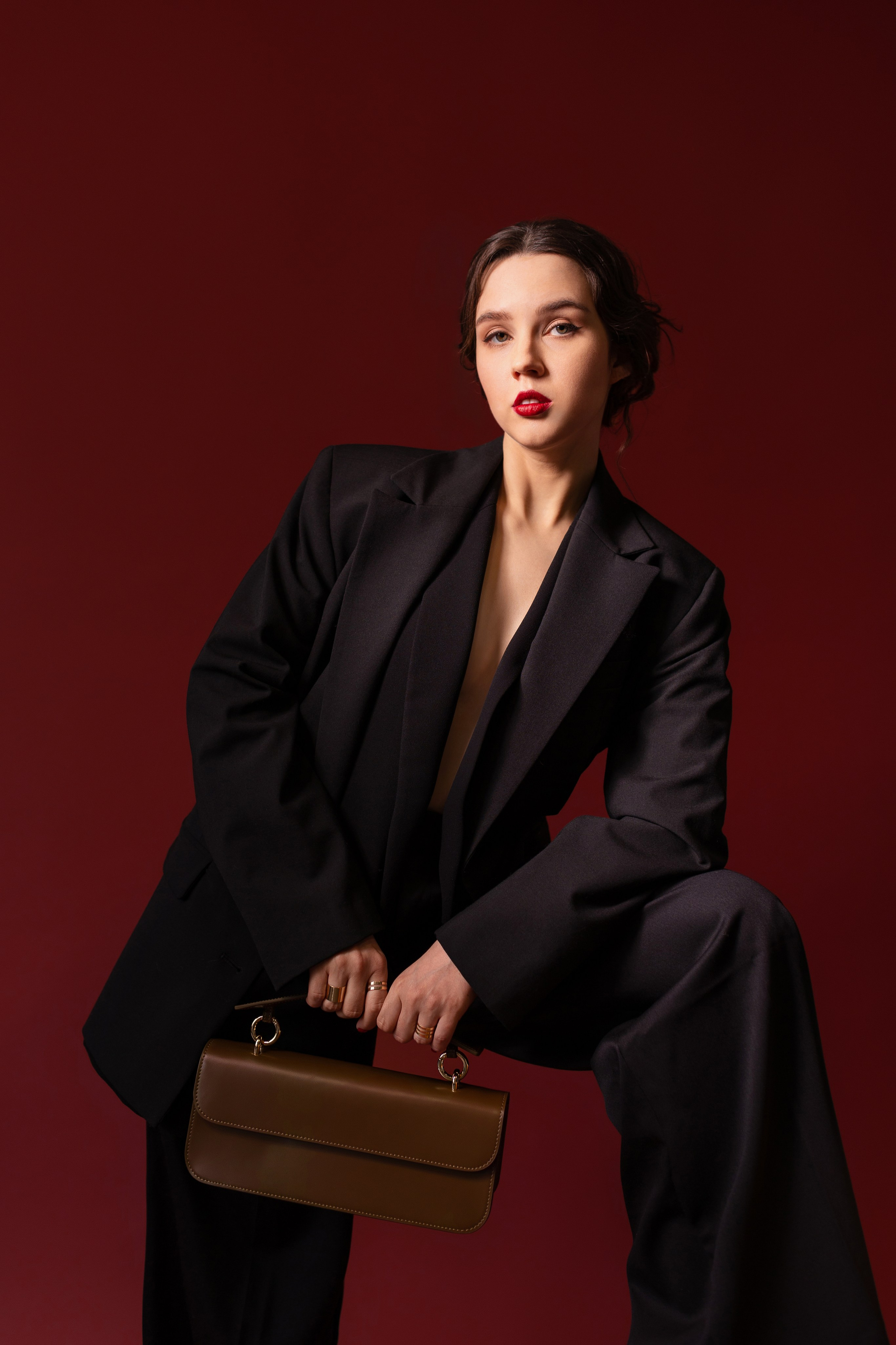 Девушка в модной одежде и с аксессуаром в руках