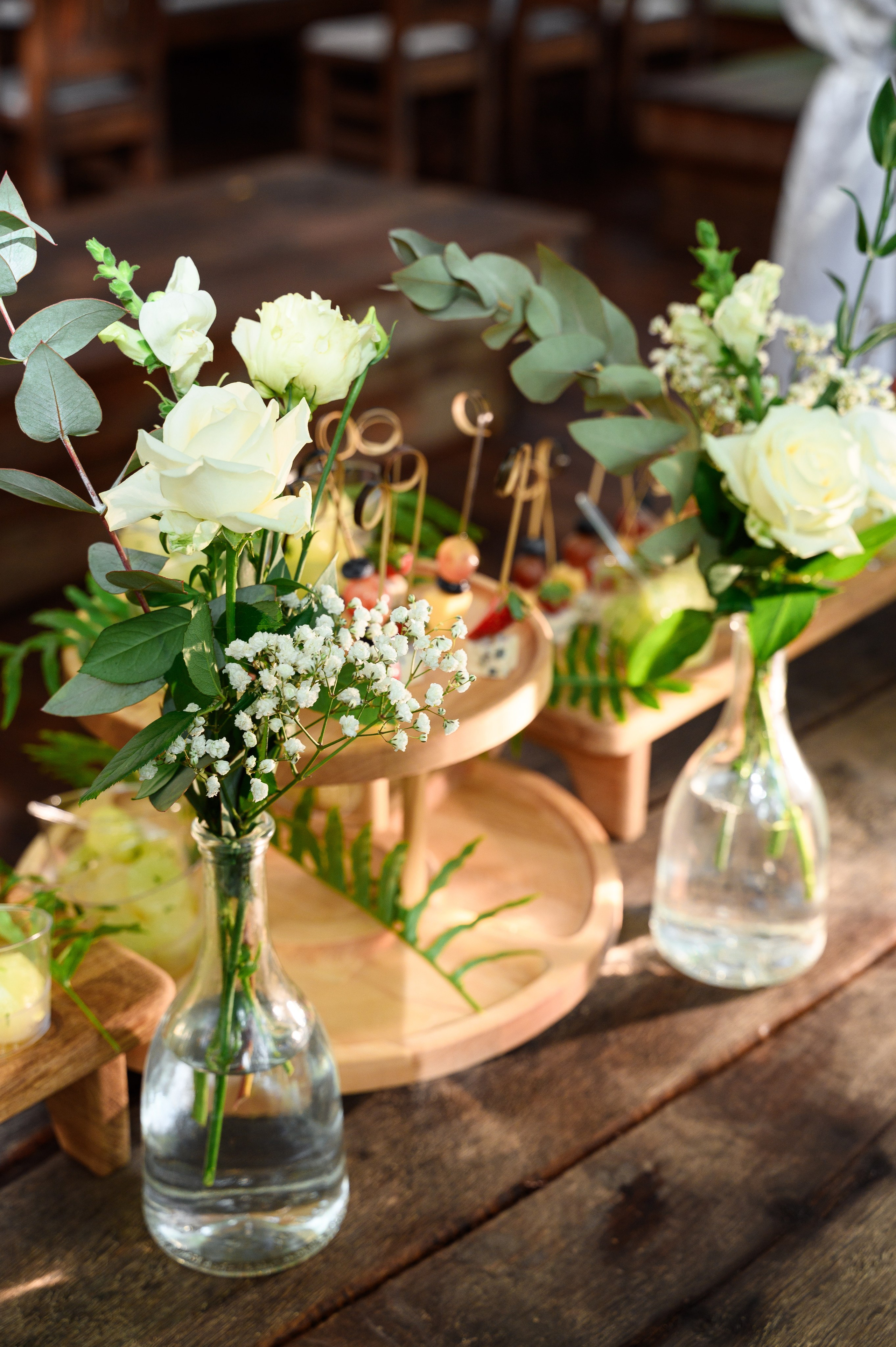 Элемент декора свадебного где стоит две вазы с цветами и поднос с едой