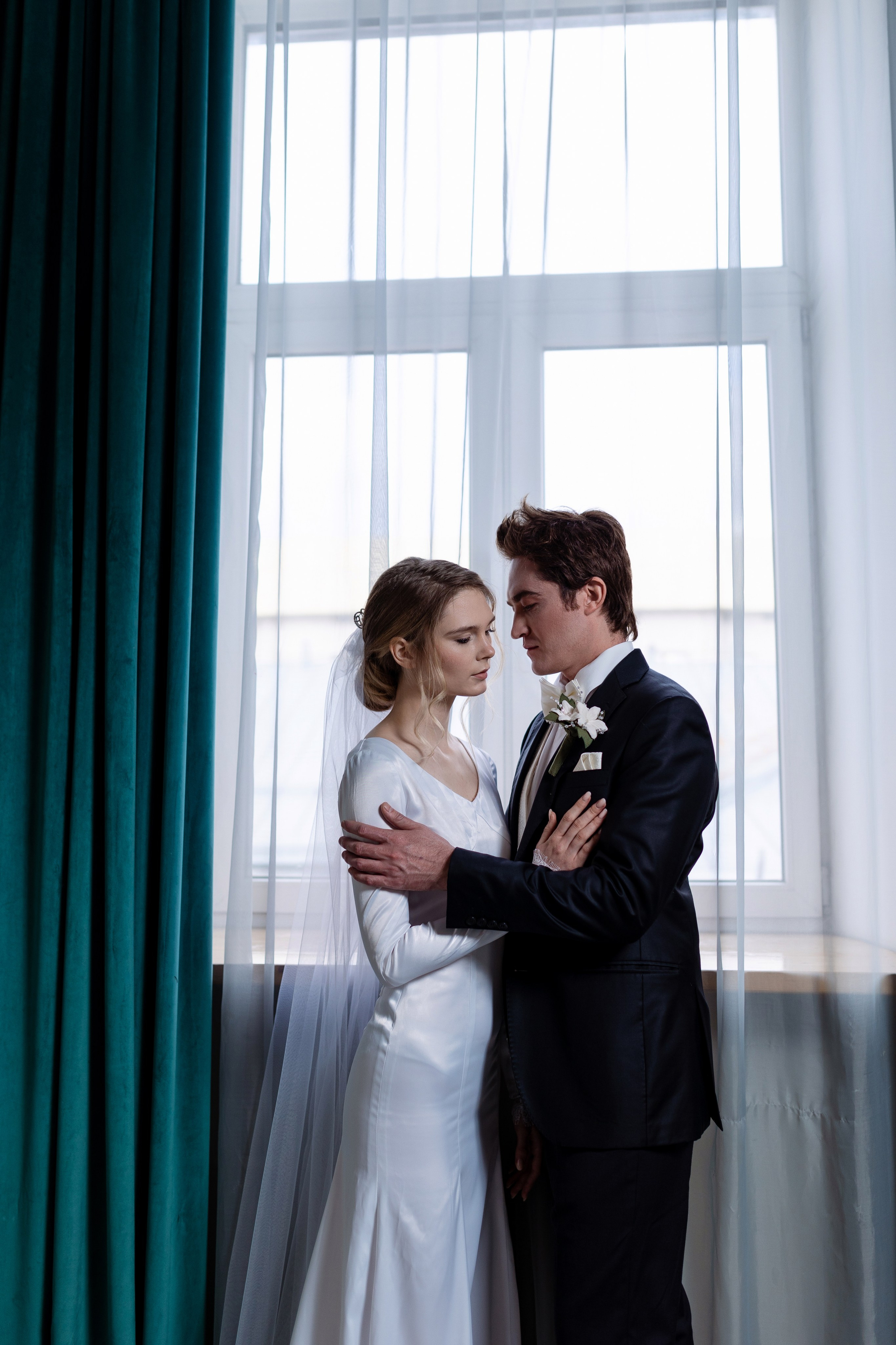 Жених смотрит на невесту и  приобнял невесту.