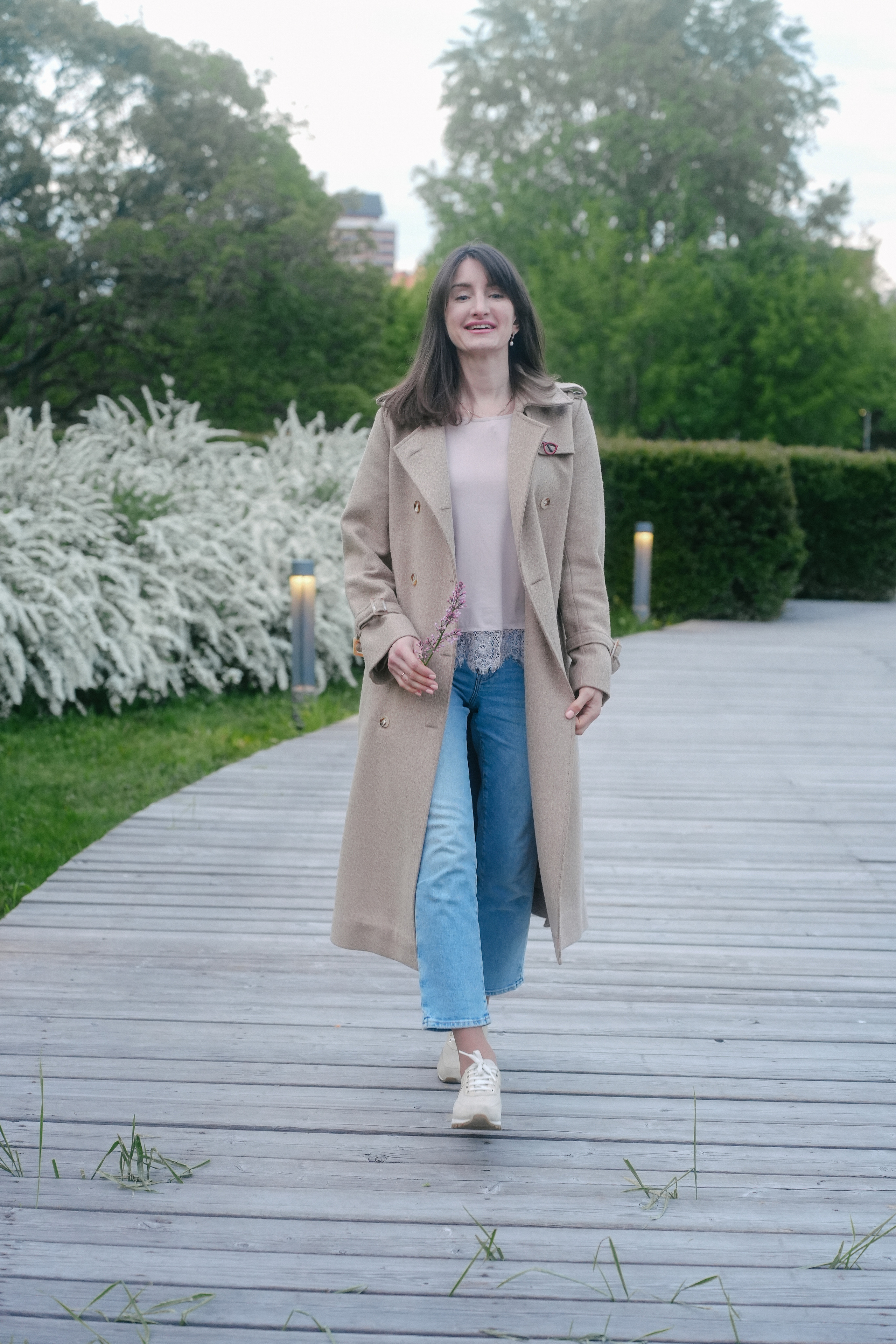 Общий план - молодая женщина гуляет по цветущему парку Музеон в мае