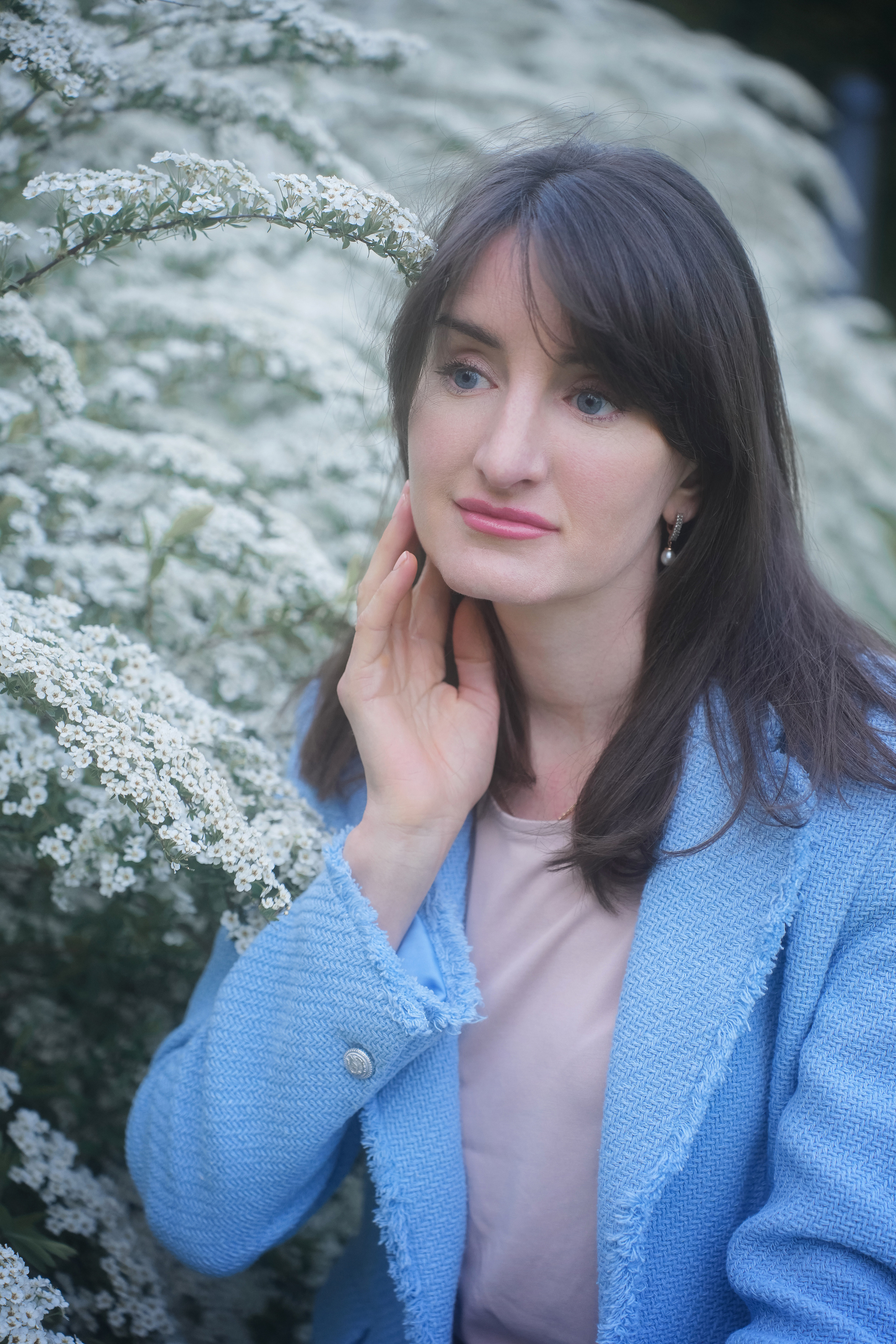 Девушка на фоне цветущей белой изумительной спиреи в парке Музеон