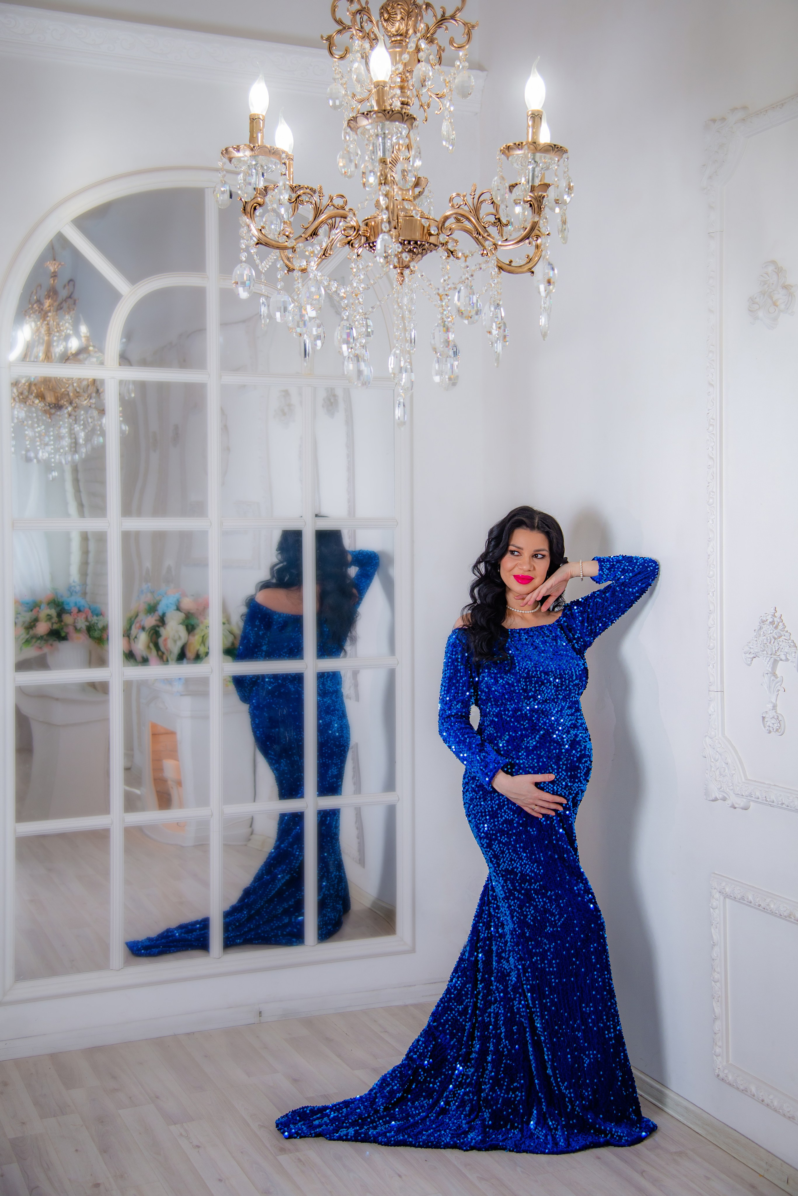 Фотосессия беременных в фотостудии в Уфе: будущая мама в элегантном платье из проката, с профессиональным макияжем и прической. Она счастливо позирует на фоне стильного интерьера, отражая красоту и нежность материнства.