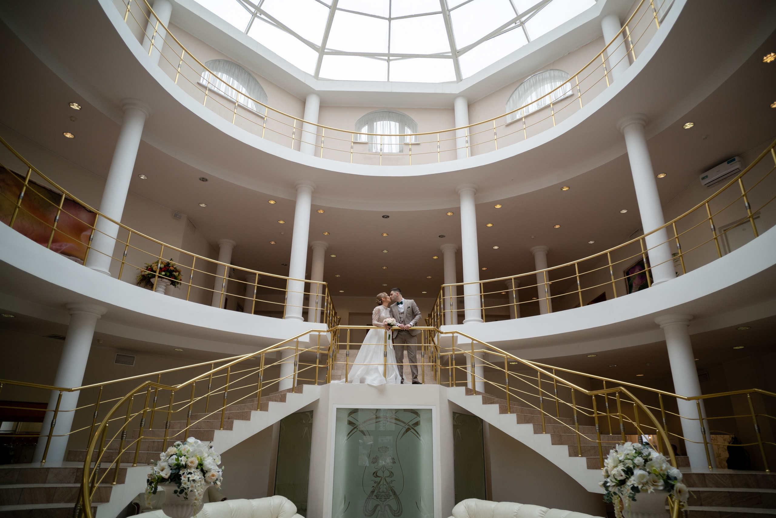 жених и невеста позируют под куполом в загсе приморского района