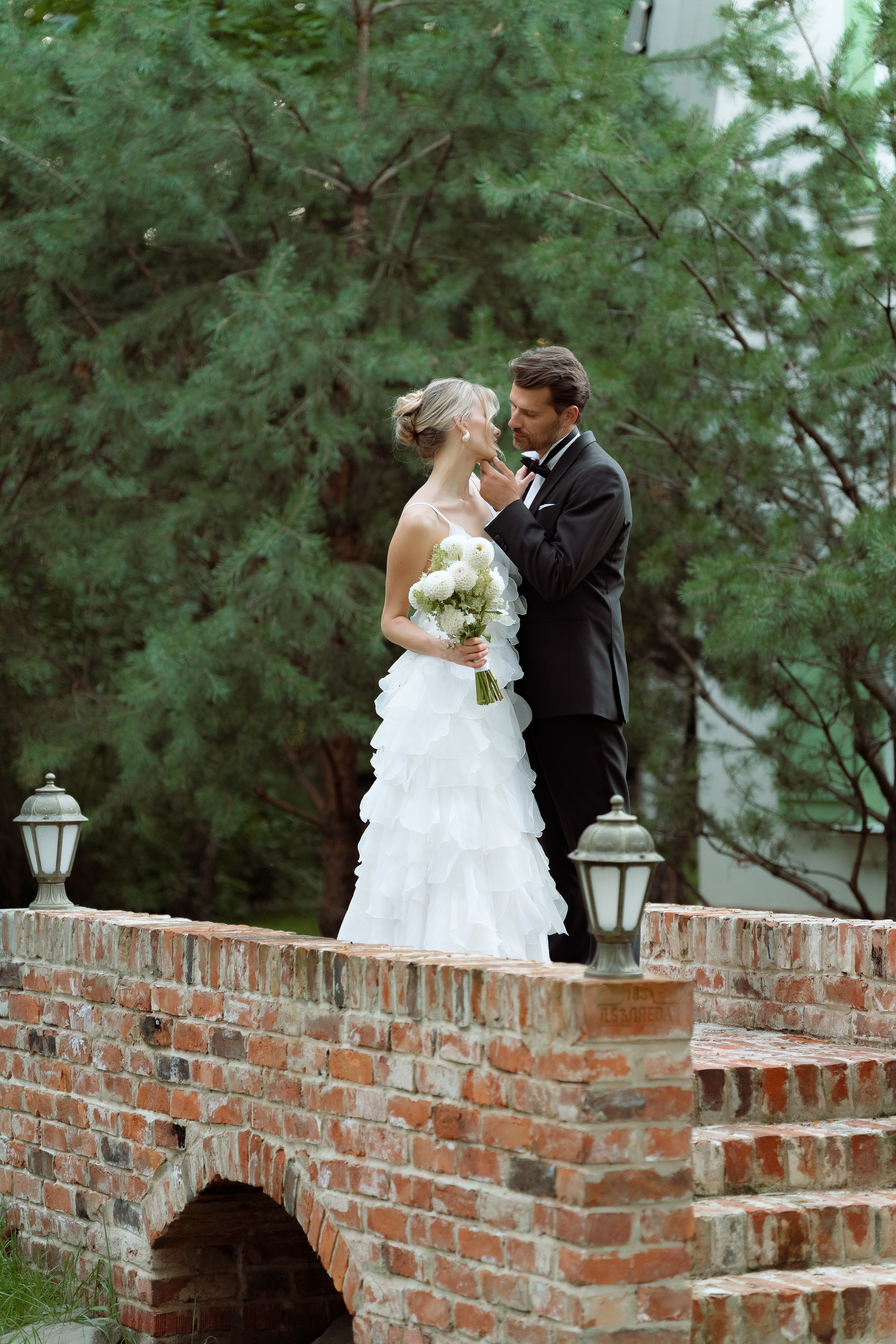 Пара после церемонии на кирпичном мостике — спокойный момент вдвоём