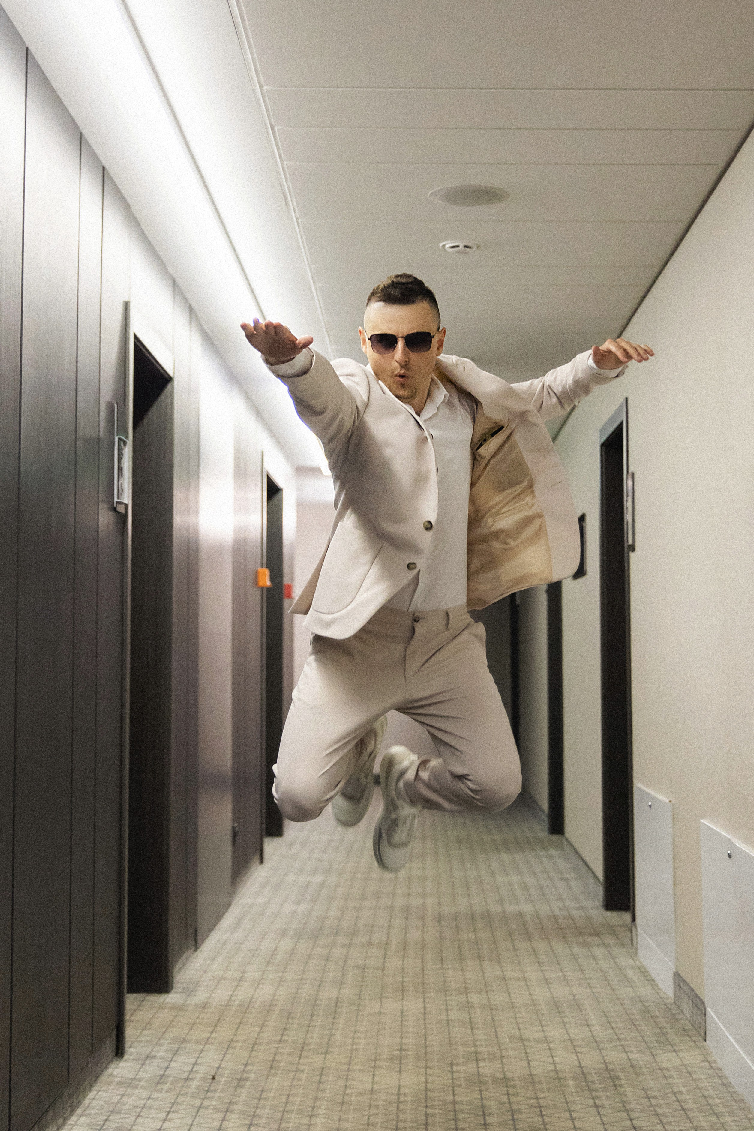 Парень изображает супермена в коридоре отеля