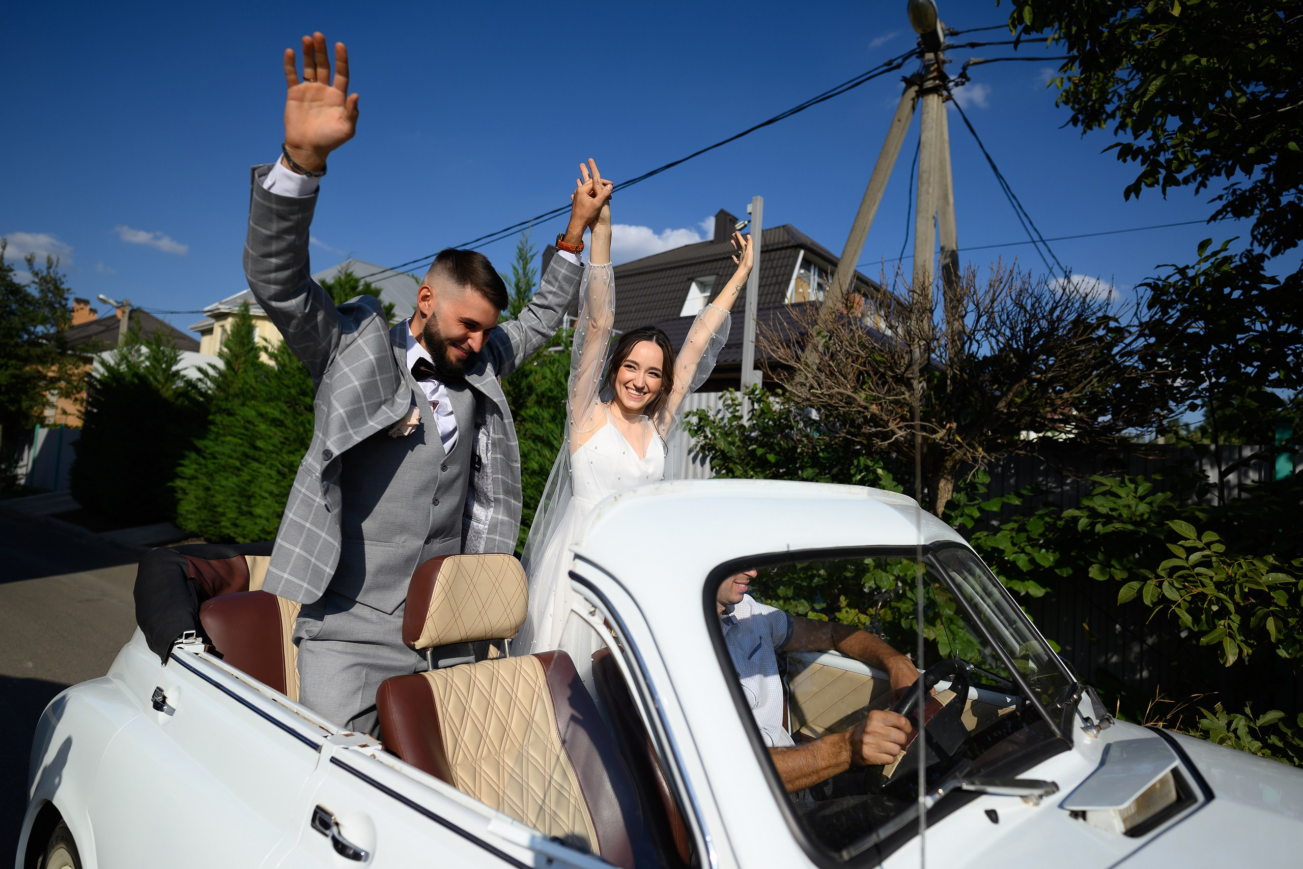 Молодожены подъезжают на банкет на кабриолете.