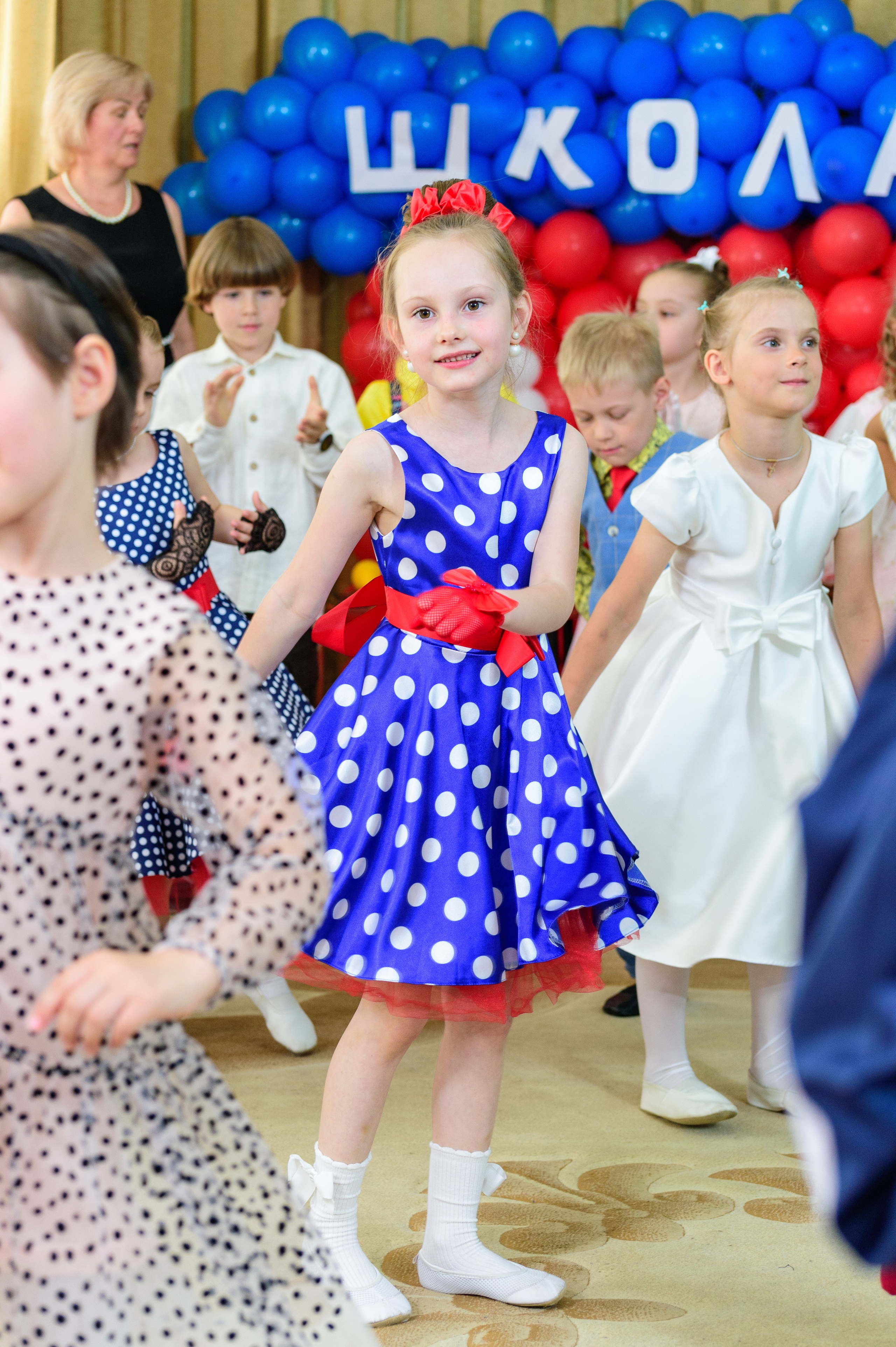 Девочка танцует на утреннике в детском саду.