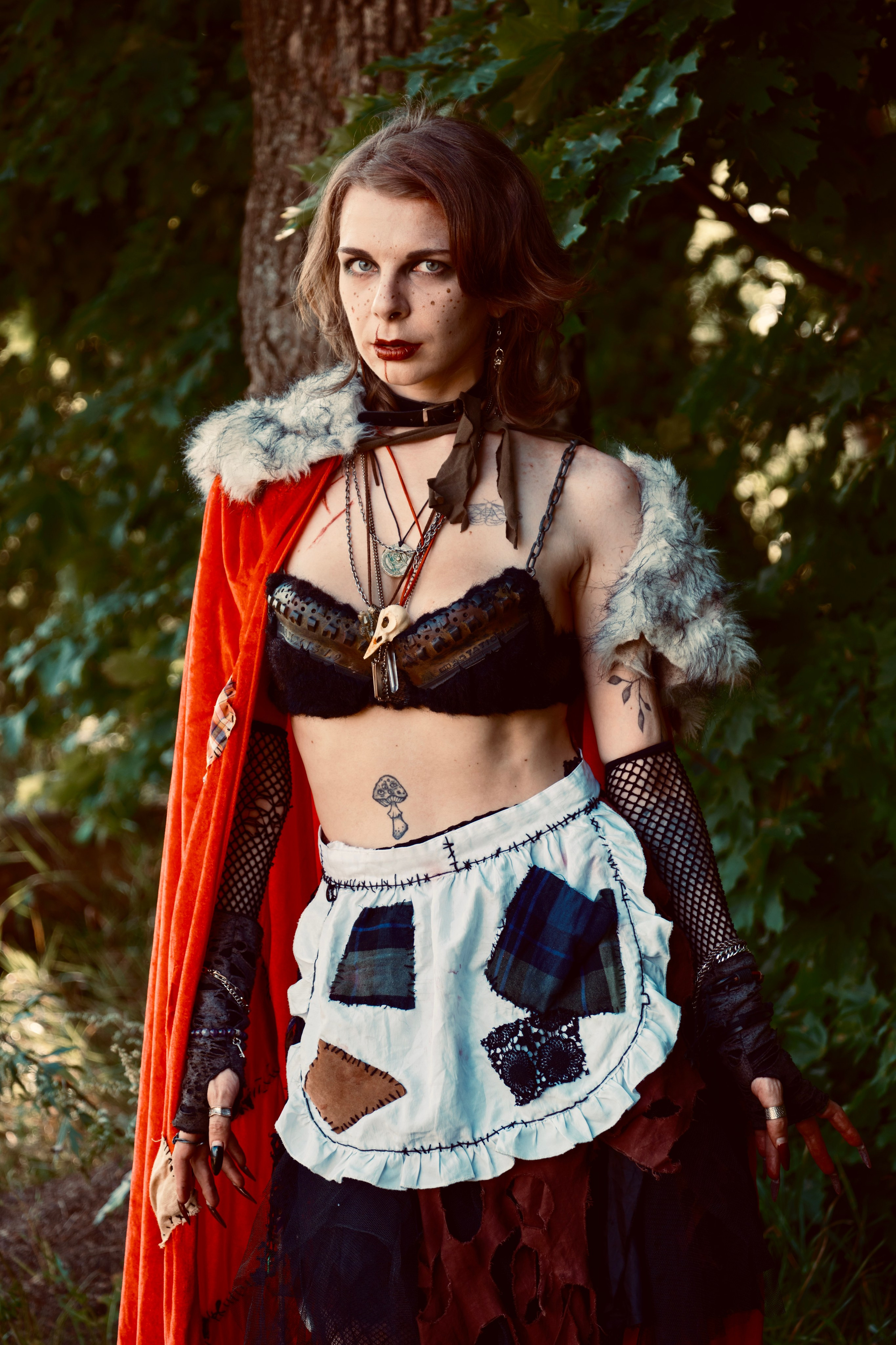 Девушка в красном плаще с корзиночкой гуляет в лесу