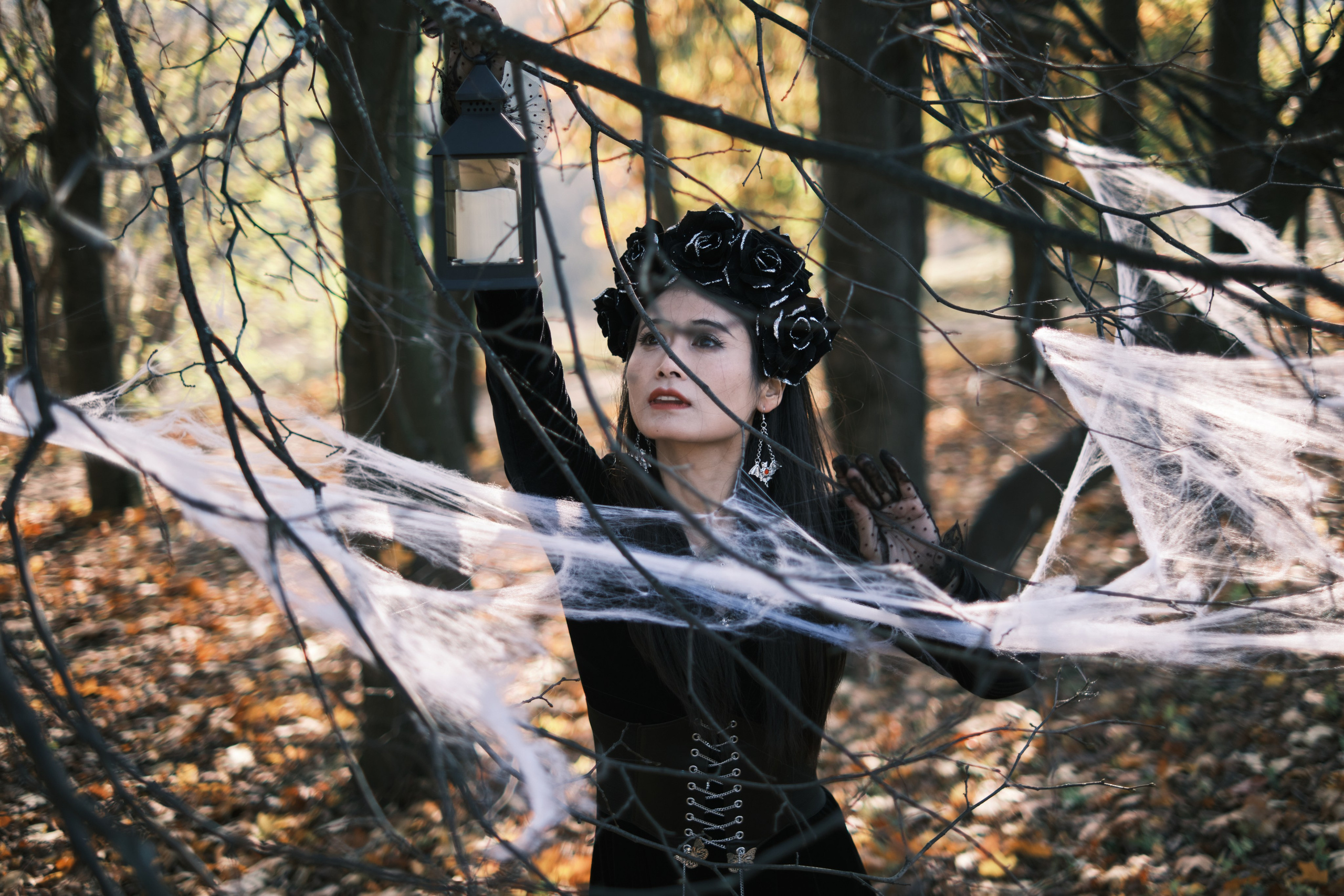Девушка в готическом костюме пробирается сквозь паутину