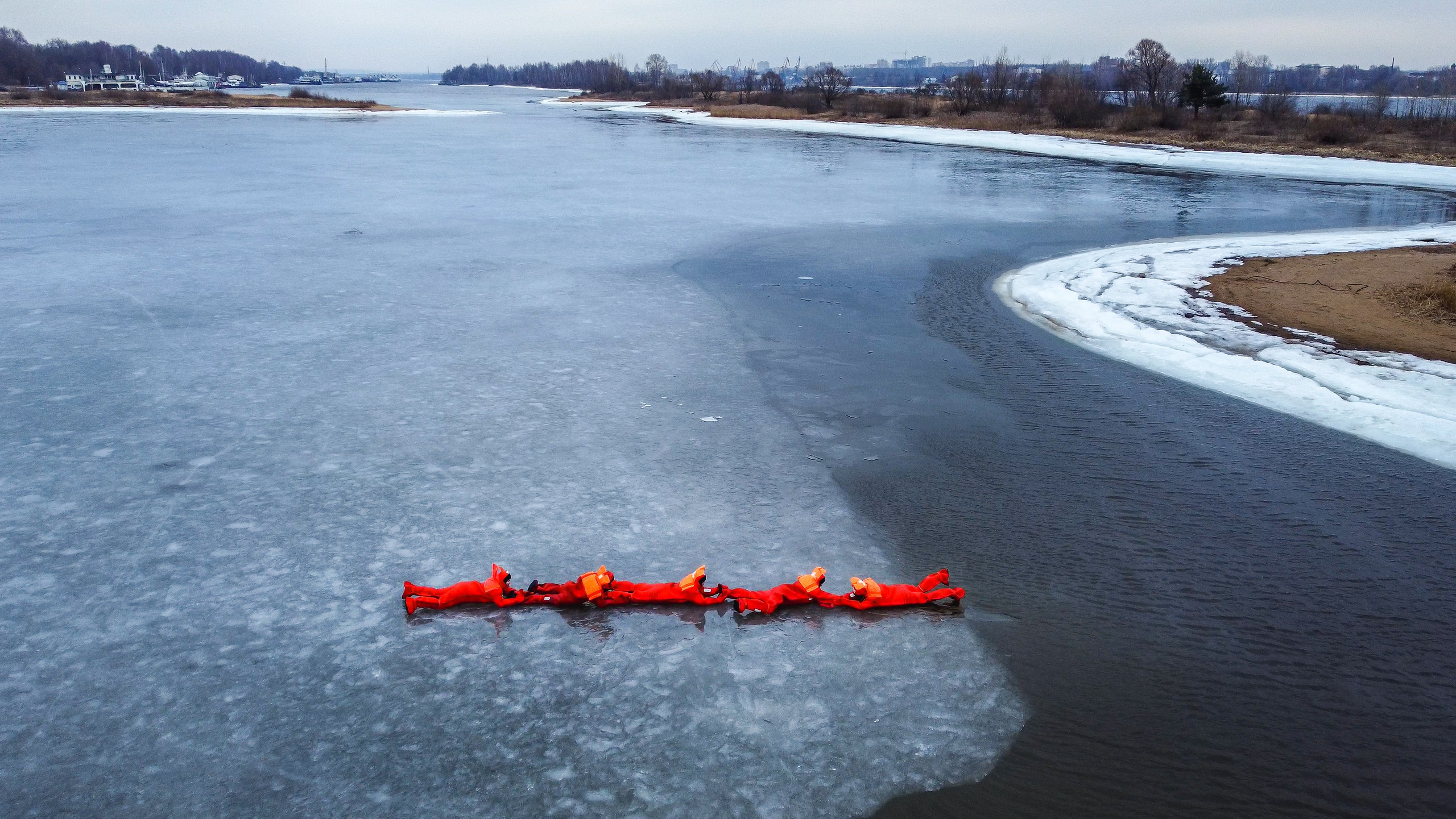 Люди купаются среди льдин, в спасательных оранжевых термо костюмах, айс флоатинг Ярославль